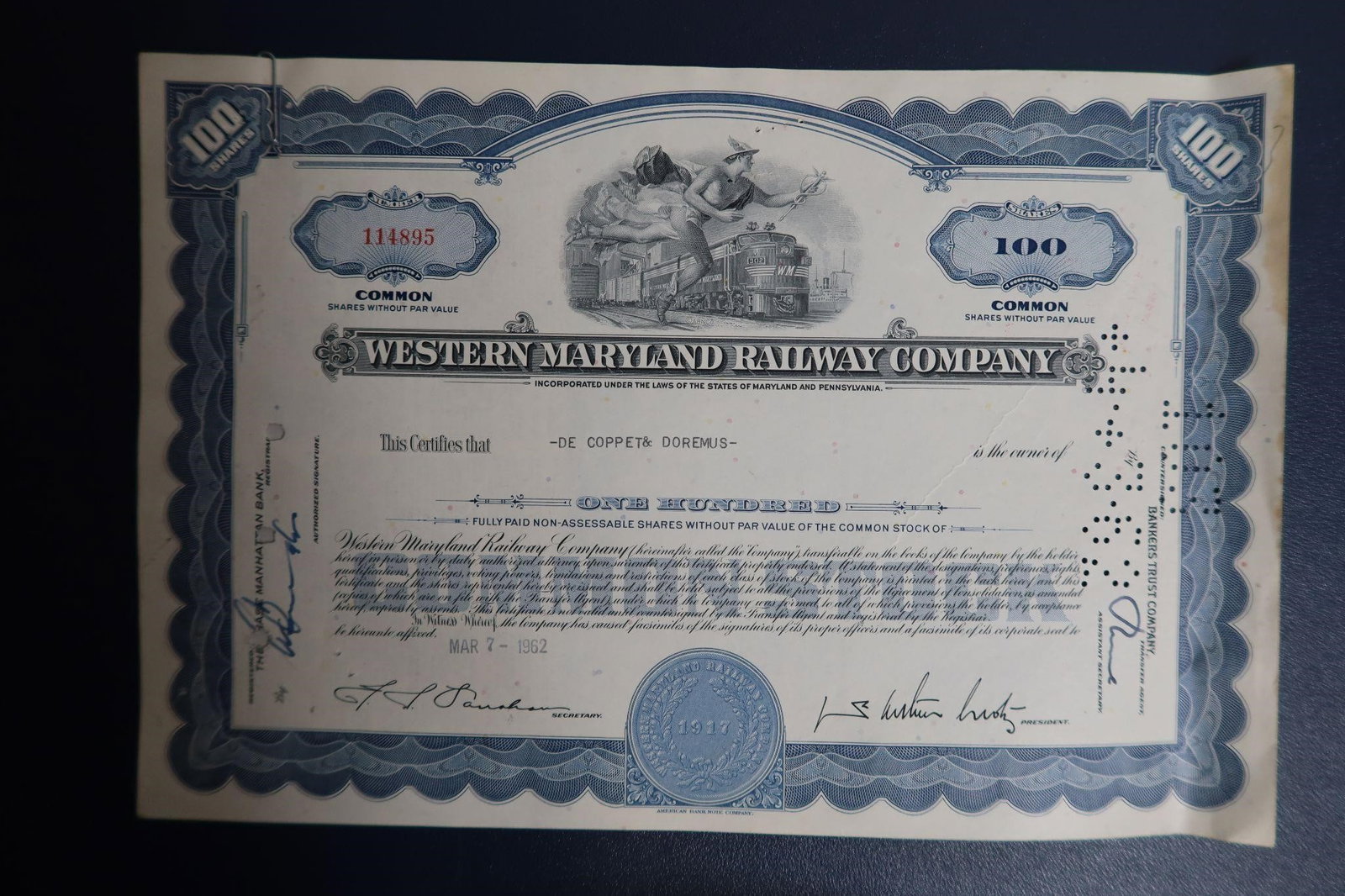Vintage Western Maryland Railway Co Certificate: A vintage Western Maryland Railway Company common stock certificate, dated March 7, 1962. It is a cancelled certificate for 100 shares without par value, issued to "De Coppet & Doremus". The