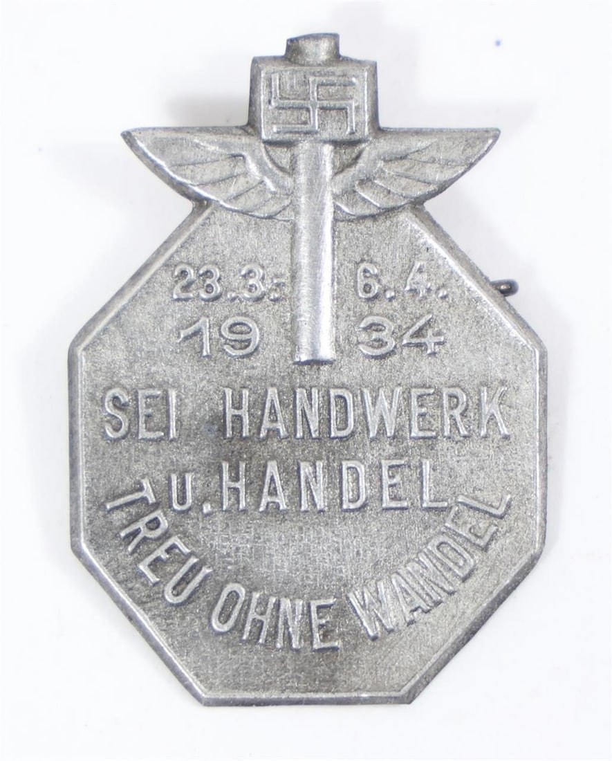 WWII German Day Badge Tinnie: The object in the image is an original WWII German Day Badge, commonly referred to as a "tinnie."