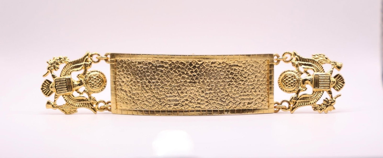 Metal Cuff, US Military decorative links..: Gold-tone metal cuff or bangle bracelet featuring an identification plate with a hammered or textured finish and eagle-shaped decorative links.Dimensions: 6.5in x 1.5in x 1/8