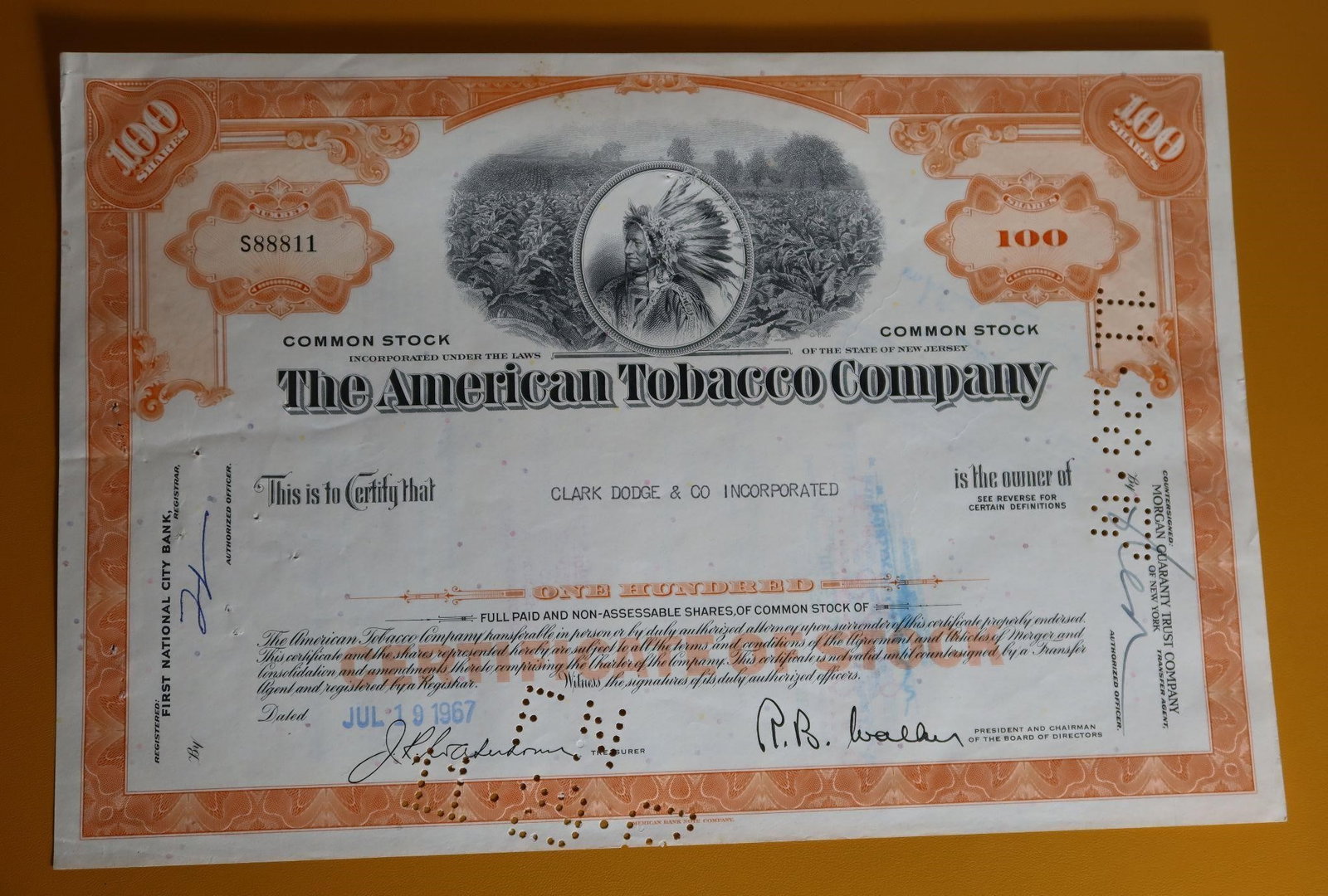 American Tobacco Company Stock Certificate: A vintage American Tobacco Company stock certificate for 100 shares, issued on July 19, 1967. It is a collectible item, valued for its historical significance and intricate design featuring a vignette
