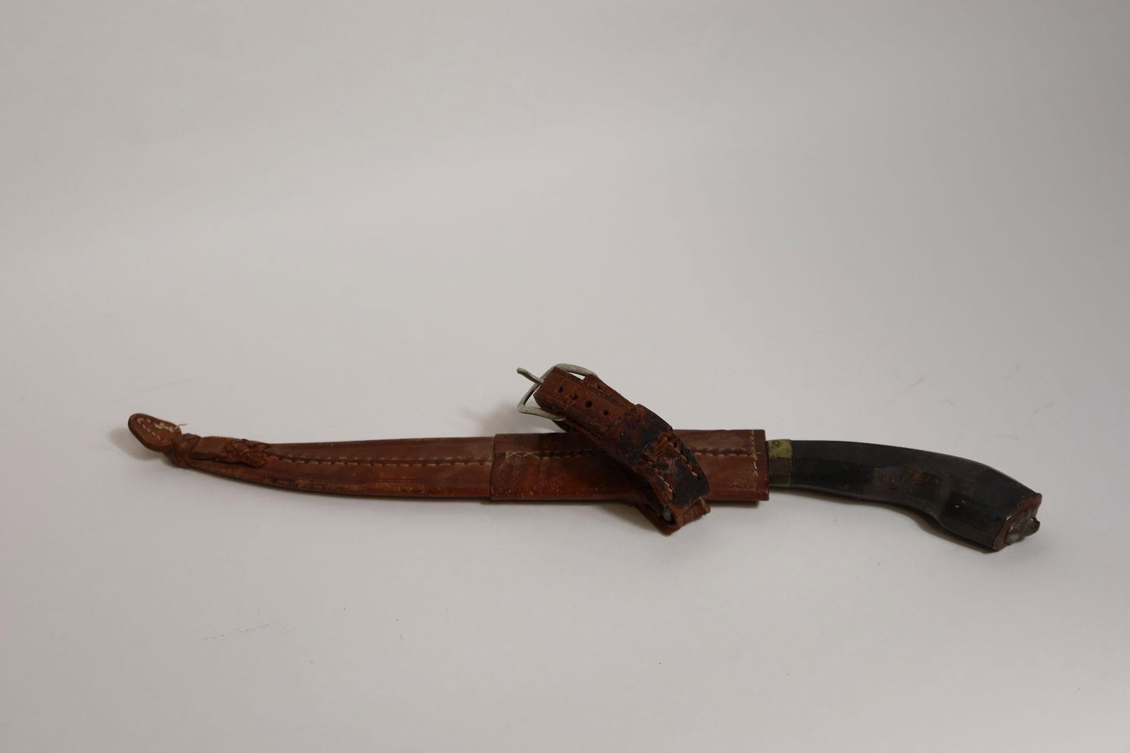 WWII Antique Bolo Knife and Sheath: The 11¾ inch (30 cm) single edge blade features a long clip point and an edge and blade bevel that begins just beyond a short, widened ricasso. A dirty, dark patina overlies transverse and