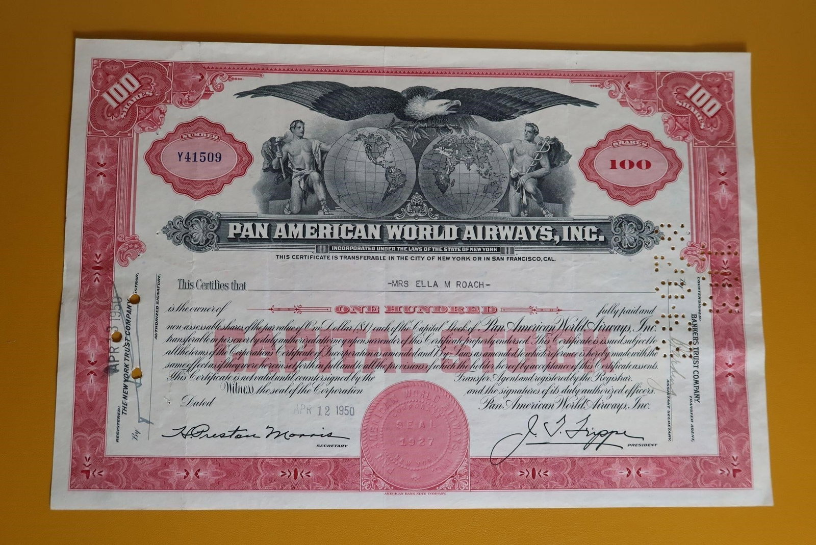 Canceled Pan Am 100 Share Stock Certificate: Issued Date: The certificate was issued on April 12, 1950, to Mrs. Ella M. Roach. Signatures: It features the printed signature of the company's founder and president, Juan Trippe. Design: The vignett