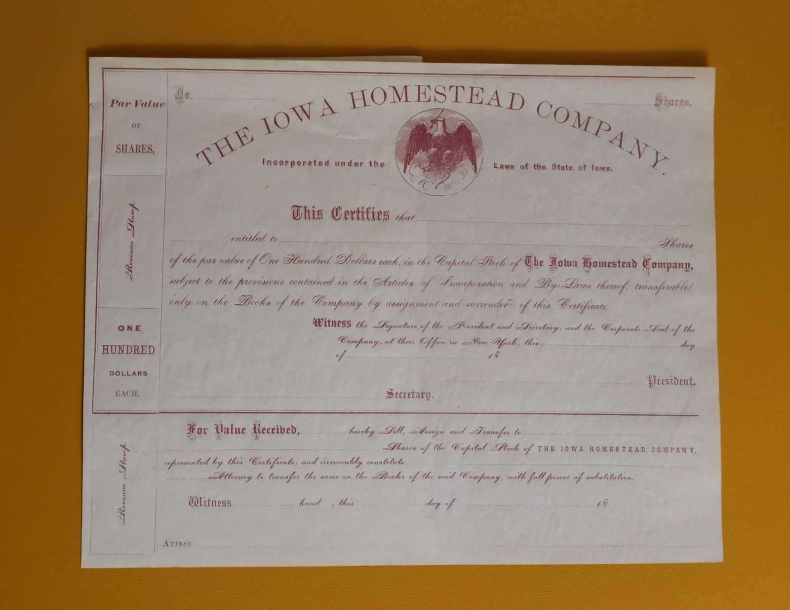 Antique Iowa Homestead Co. Stock Certificate: An antique stock certificate for The Iowa Homestead Company. It is incorporated under the laws of the State of Iowa. Each share has a par value of One Hundred Dollars. The certificate is transferable