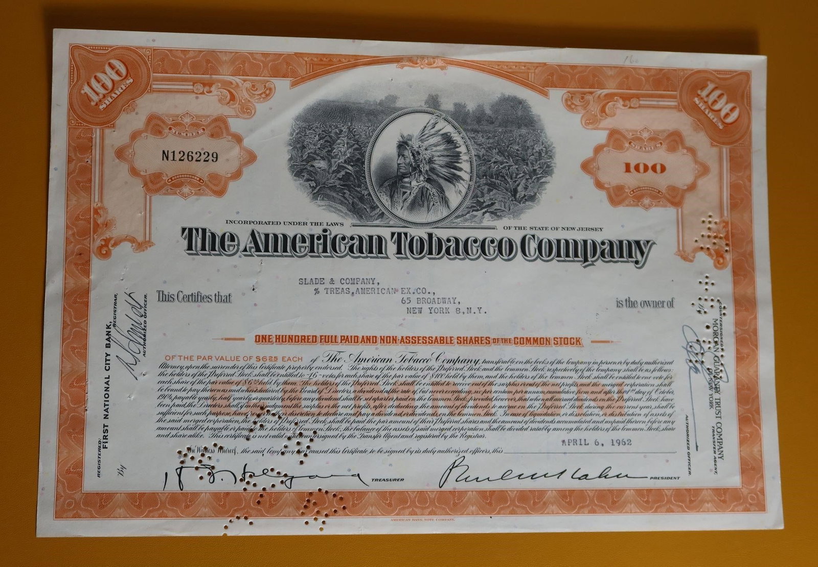 Historic American Tobacco Co Stock Certificate: An original, historic American Tobacco Company stock certificate. It represents one hundred shares of common stock, issued to Slade & Company on April 6, 1952. The certificate features an ornate