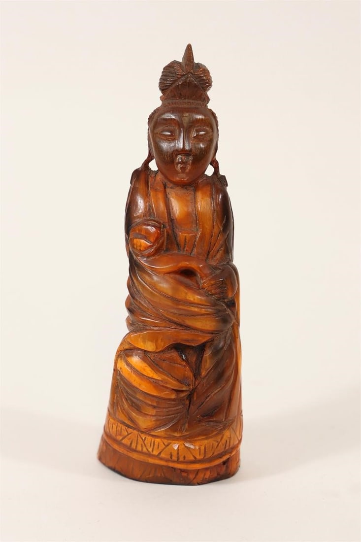 Carved Horn Figure Sculpture: Decorative hand-carved figure crafted from horn, featuring a rich reddish-brown coloration and finely detailed workmanship. Depicted in flowing robes with expressive facial features and intricate