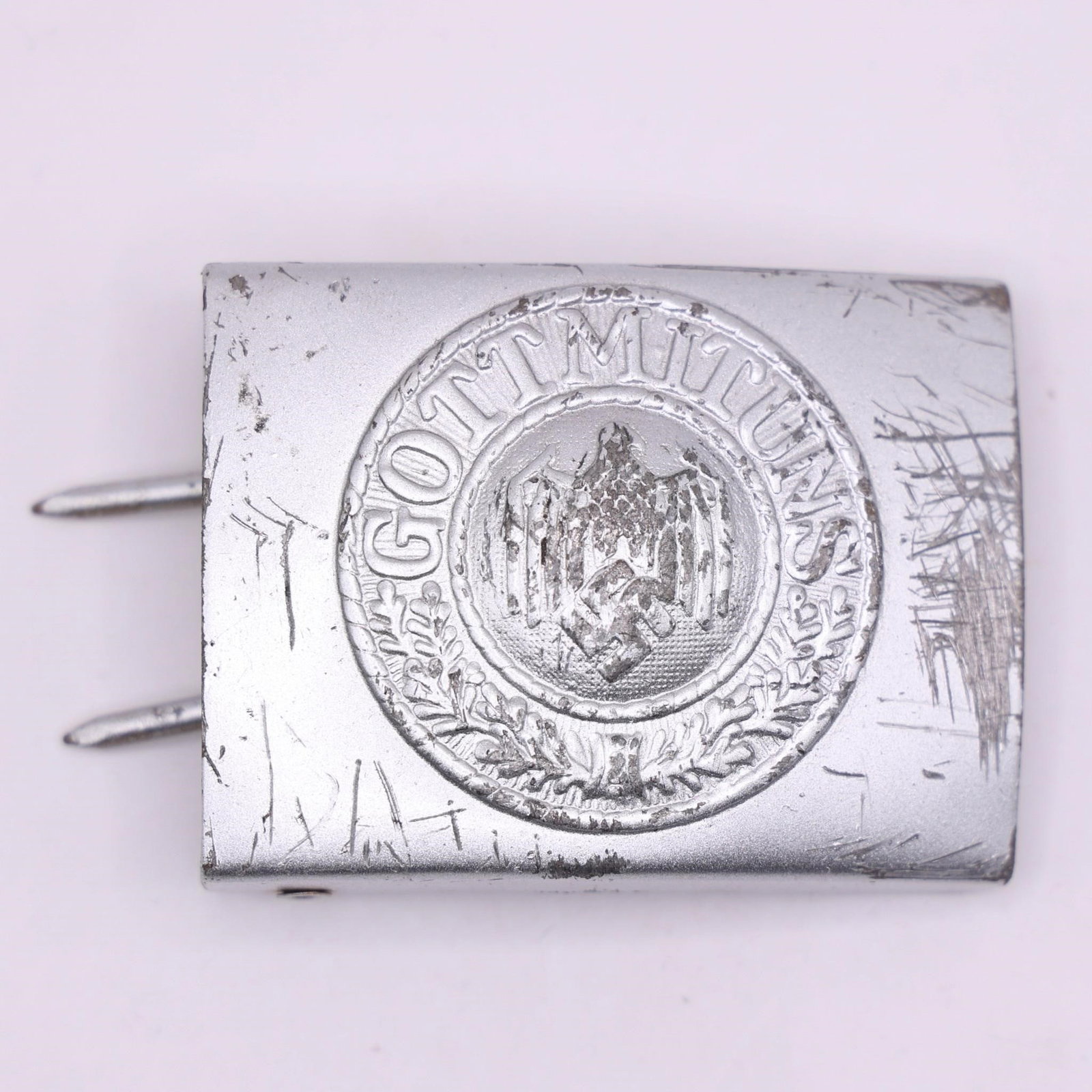 German WWII "Gott Mit Uns" Wehrmacht Belt Buckle: This German Military "Gott Mit Uns" belt buckle is styled after the World War II-era Wehrmacht design, featuring the iconic eagle emblem surrounded by an oak leaf wreath. The front displays the tradit