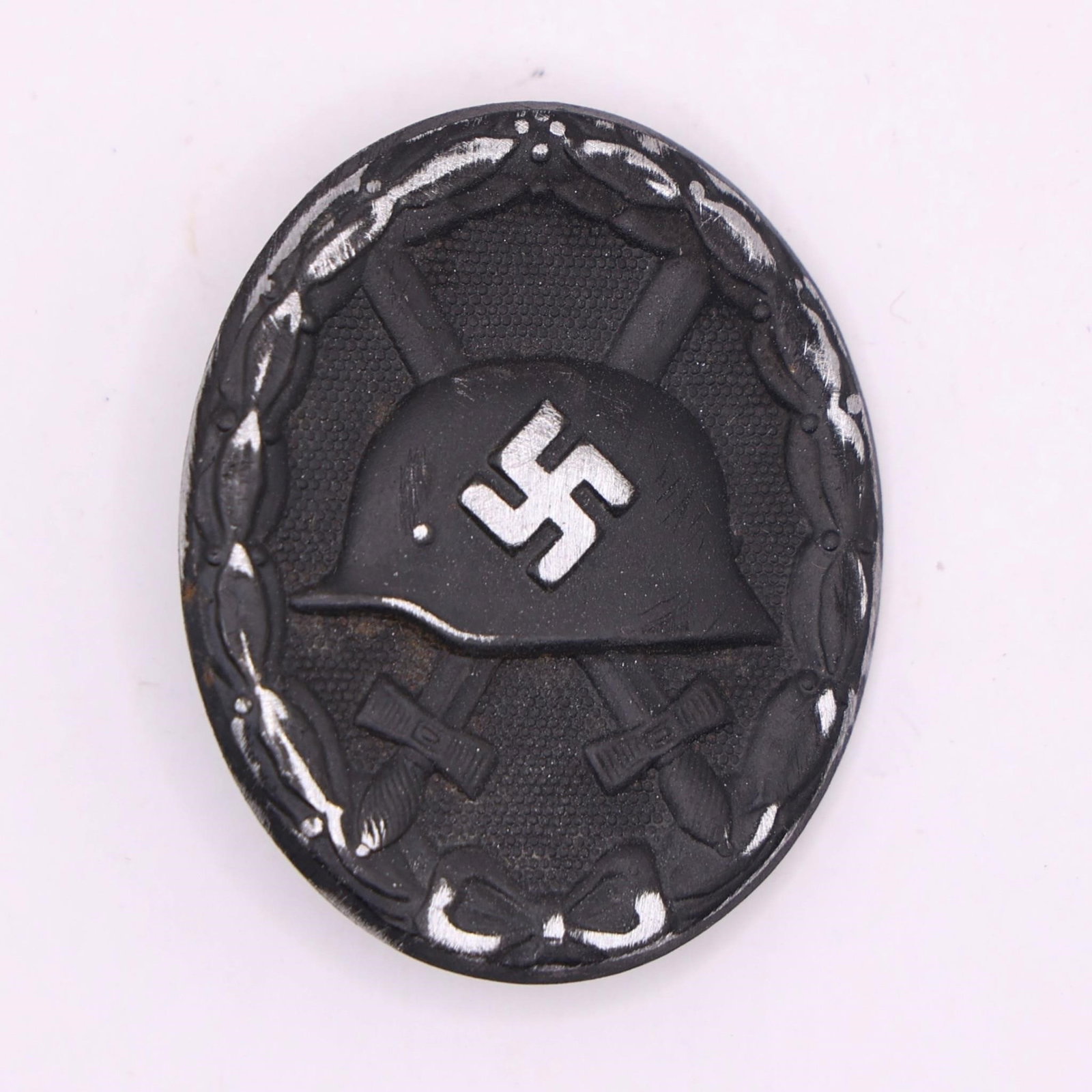 World War II German Wound Badge - Silver Grade: World War II German Wound Badge, cast zinc with a silver-plated finish, measuring approximately 44 × 36.5 mm. Exhibits age-related wear, patina, and handling marks consistent with age and use.