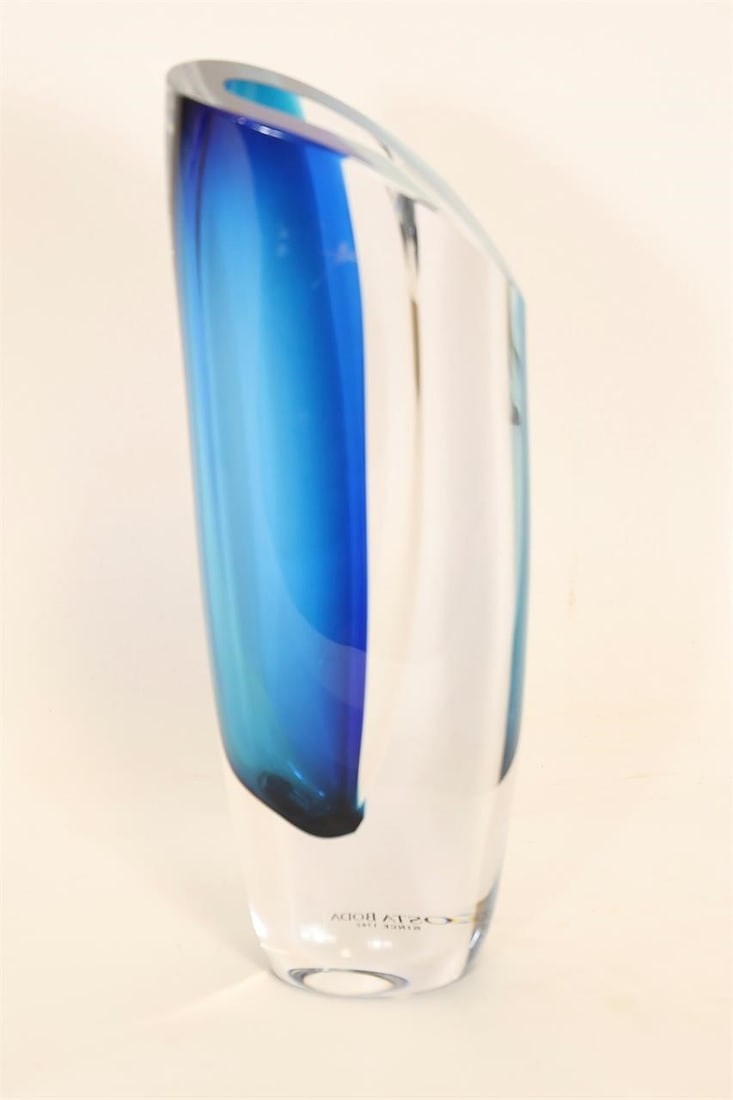 Göran Wärff Kosta Boda Blue Art Glass Vase: Designed by renowned Swedish artist Göran Wärff for Kosta Boda, this striking art glass vase is distinguished by its rich cobalt blue color and elegant asymmetrical form. The fluid, organic