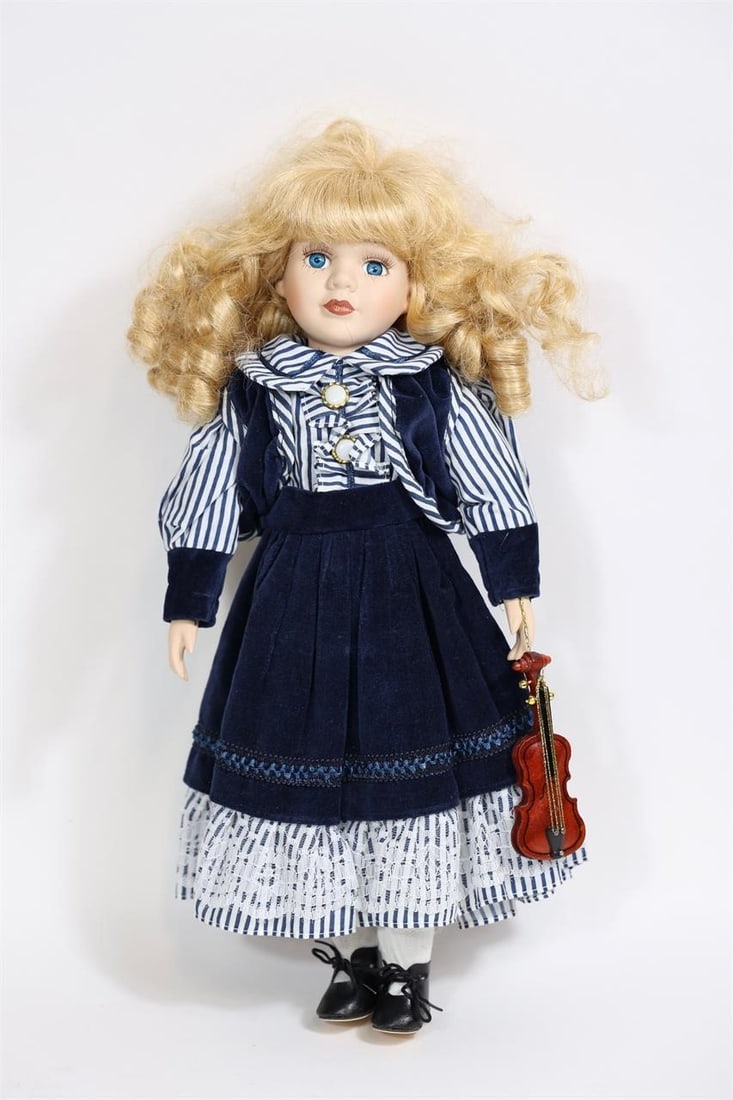 Vintage Porcelain Doll with Violin: Vintage porcelain doll featuring a porcelain head, hands, and feet with a soft cloth body. The doll has blonde curled hair and is dressed in a blue velvet-style dress with striped blouse, lace trim,