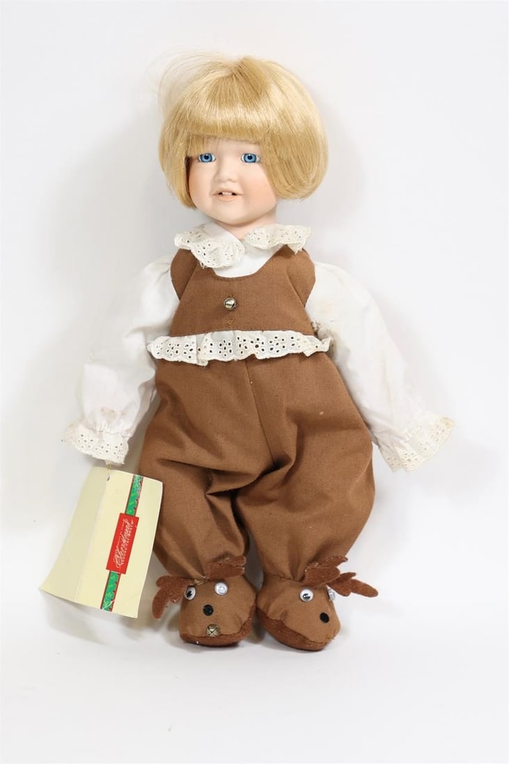 House of Lloyd Porcelain Christmas Doll: House of Lloyd "Christmas Around the World" porcelain doll titled "Oh! What a Deer." Features a porcelain head, hands, and feet with a soft stuffed body, dressed in a brown reindeer-themed outfit