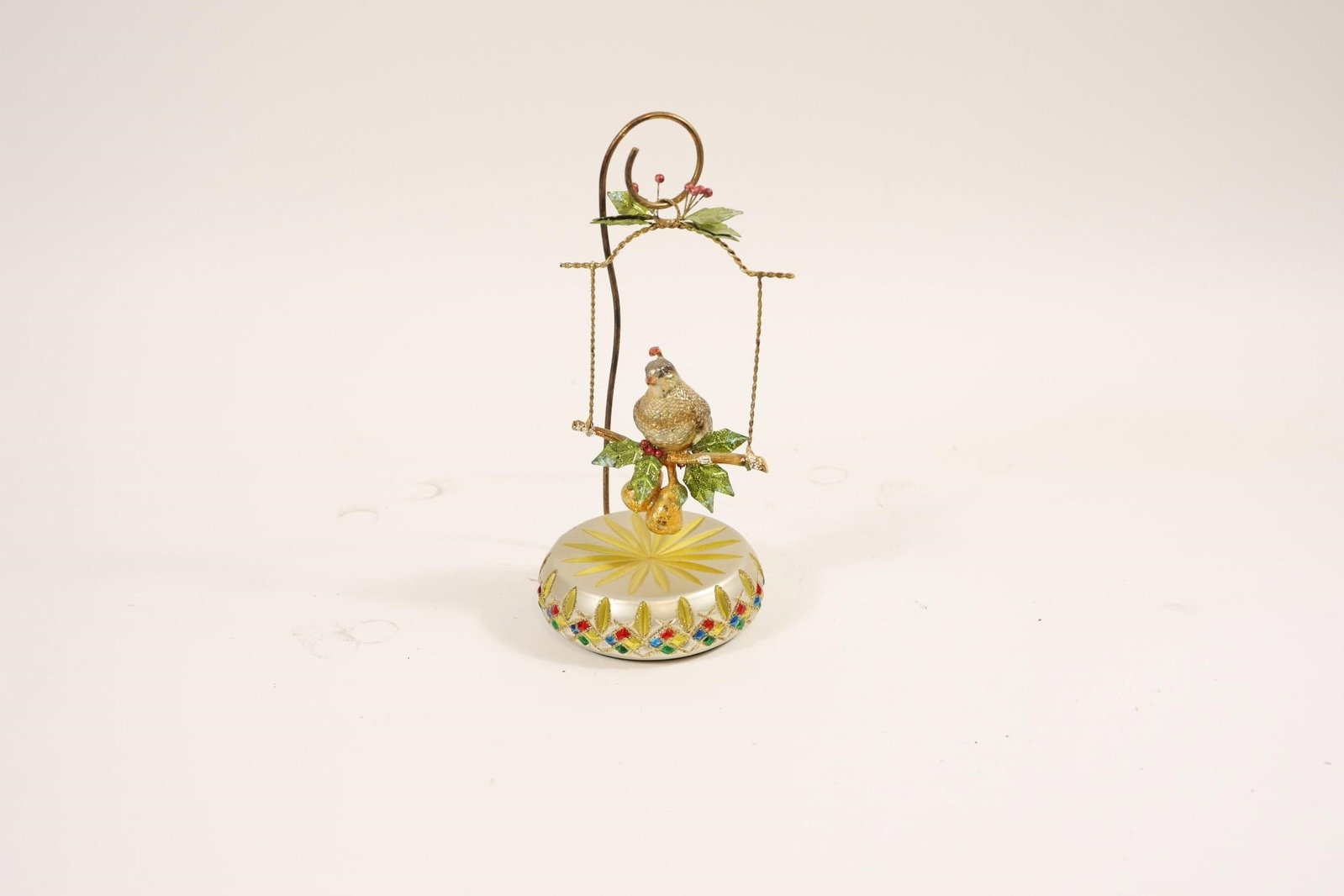 Vintage Bird Music Box Figurine: Vintage collectible music box featuring a bird perched on a branch, suspended from a decorative stand above a patterned base; finely detailed with charming design, producing music when wound, ideal