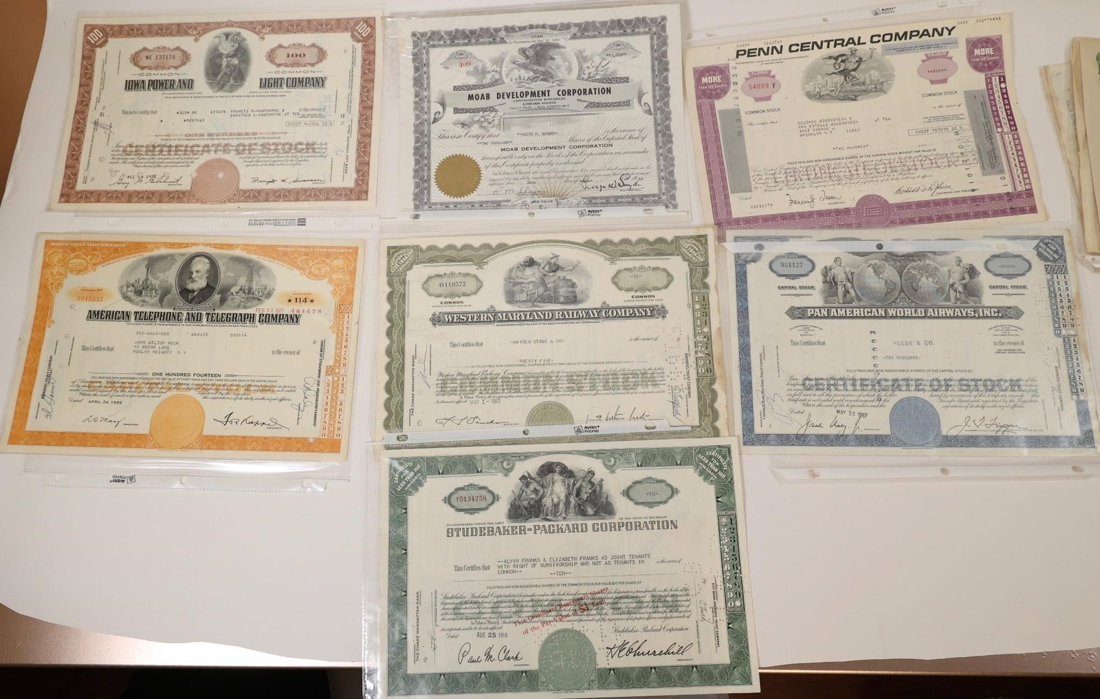 Vintage Stock Certificate Collection: Collection of seven vintage stock certificates featuring Iowa Power & Light Company, Road Development Corporation, Penn Central Company, American Telephone & Telegraph (AT&T), Western Maryland
