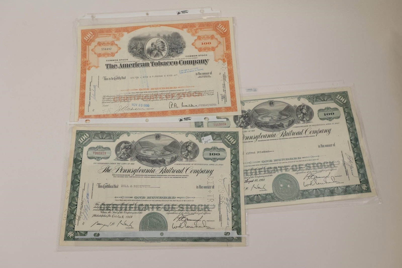 American Tobacco & Railroad Stock Certificates: Collection of three vintage stock certificates including two Pennsylvania Railroad Company certificates and one American Tobacco Company common stock certificate. Features engraved artwork, company se