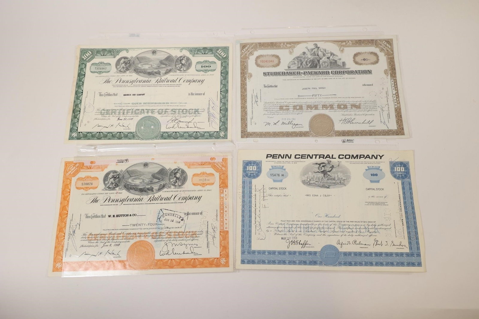 Pennsylvania Railroad & Studebaker Certificates: Group of four vintage stock certificates featuring Pennsylvania Railroad Company (2), Studebaker-Packard Corporation, and Penn Central Company. Includes engraved artwork, corporate seals, signatures,