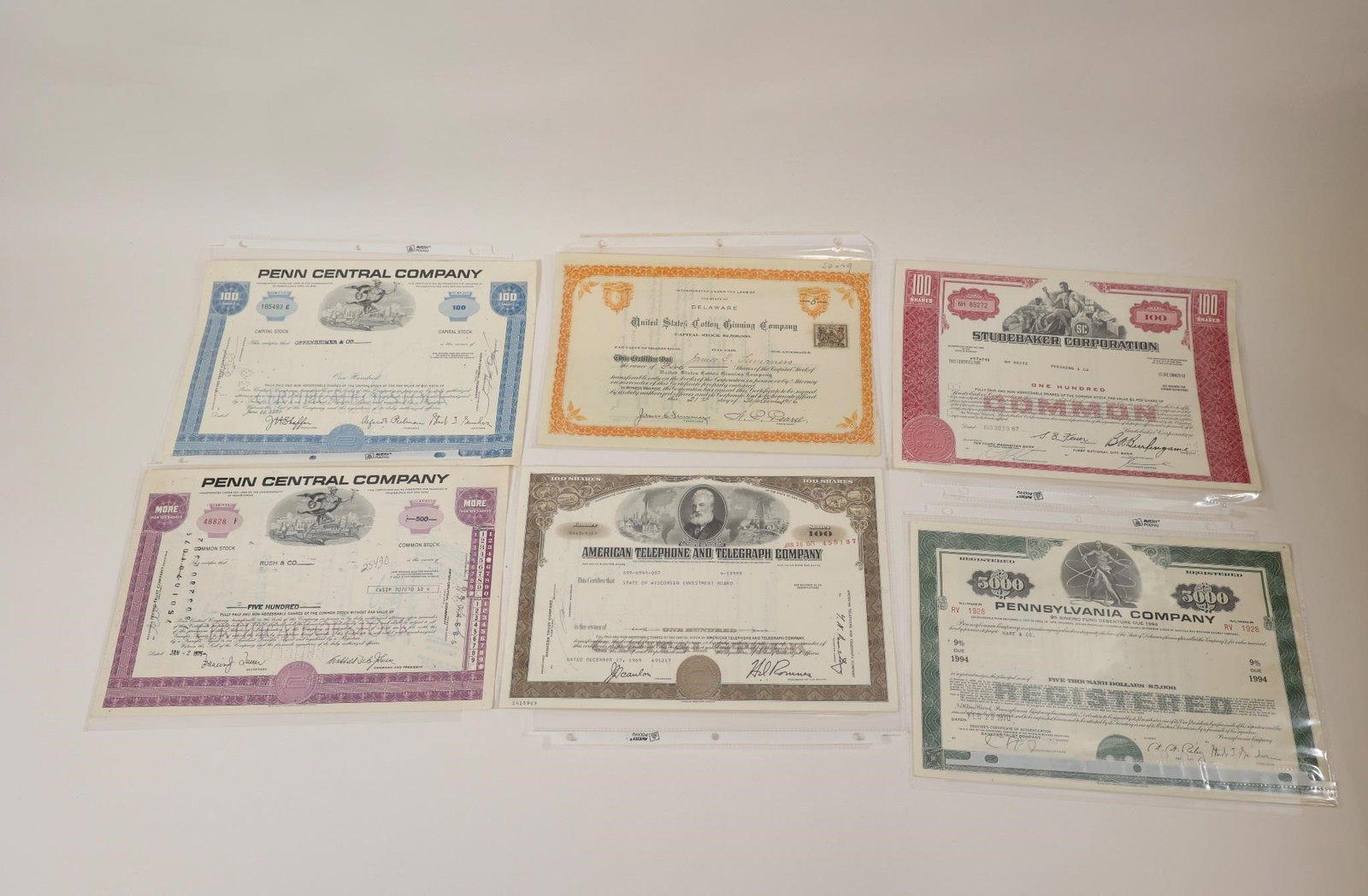 Vintage Stock Certificate Collection: Collection of six vintage stock certificates including Penn Central Company, Studebaker Corporation, American Telephone & Telegraph Company (AT&T), Pennsylvania Company, and other corporate securities