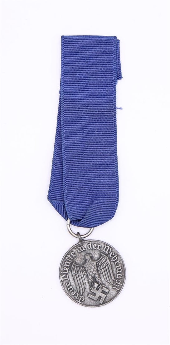 Original WWII German Four Year Long Service Medal: Original WWII German Four Year Long Service Medal, approximately 31 mm in diameter, silver-washed, die-struck, and made of magnetic sheet metal. The obverse shows an embossed Wehrmacht-style eagle wit