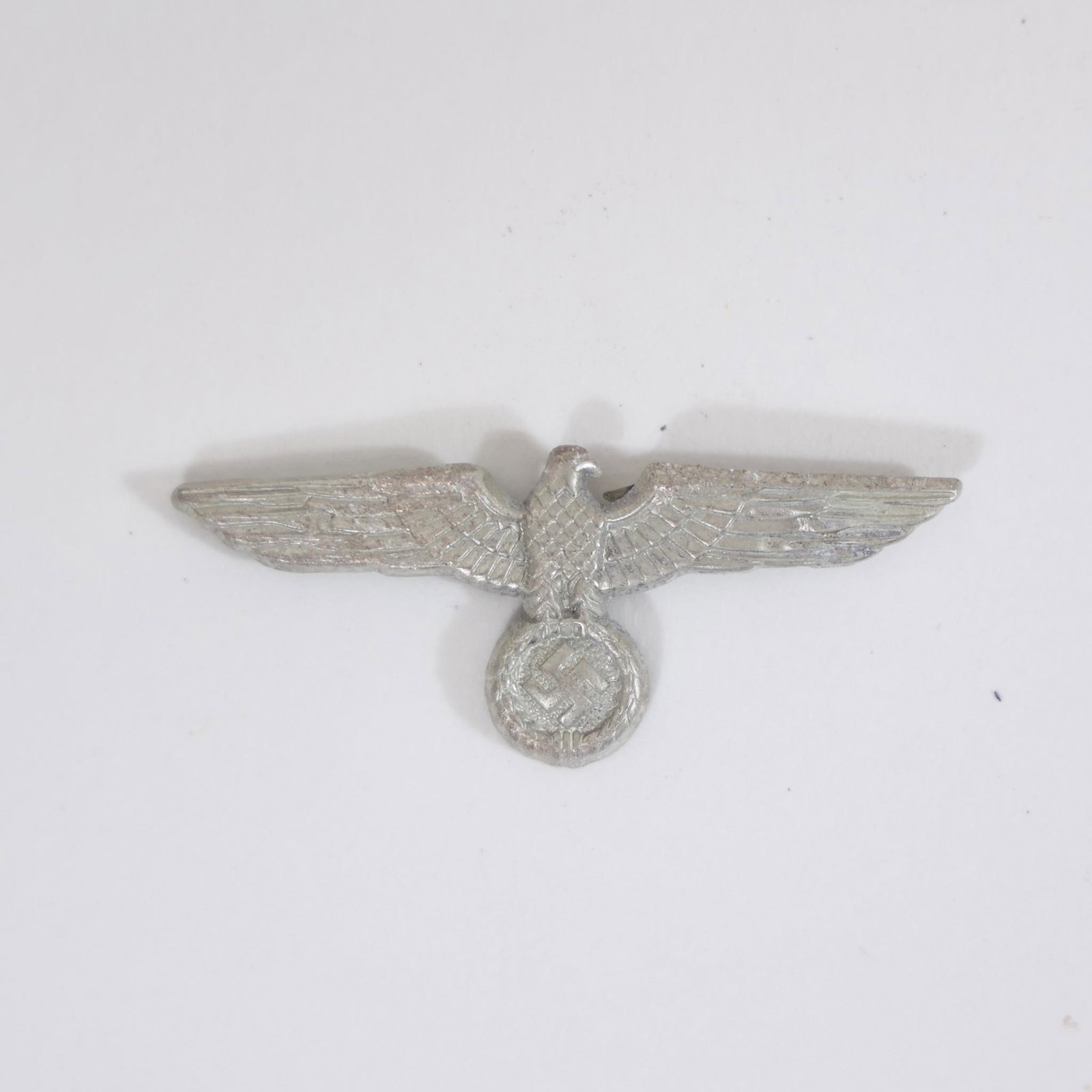 German Wehrmacht Heer Visor Cap Eagle Insignia: Vintage German Army (Wehrmacht Heer) visor cap eagle insignia from World War II era, featuring detailed spread-wing eagle design worn on military headgear, collectible WWII militaria piece.