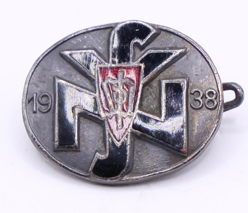 Sudeten Party / NSV Badge (1938): Silvered bronze badge with red and black enamels, depicting the Sudeten Party insignia over a National Socialist People's Welfare emblem, flanked by "19" and "38" (1938). Horizontal pinback with dark