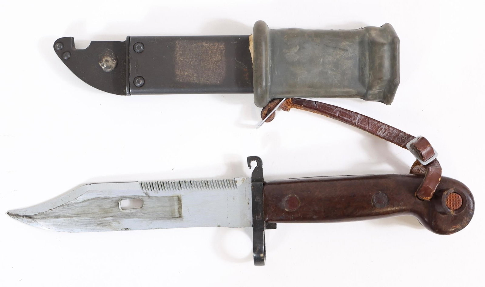 Russian Military Bayonet w/ Scabbard: Russian military bayonet featuring a fullered blade with sawback spine, steel guard with muzzle ring, and brown composite grip with rivets. Marked "BK 2531" on guard. Includes metal scabbard with rubb