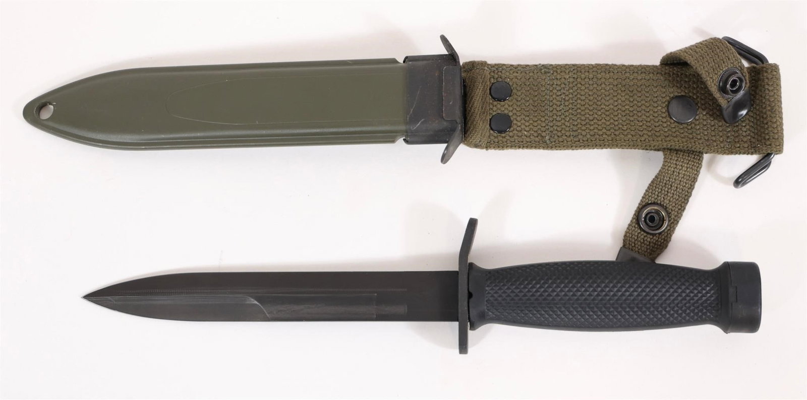 US Fighting Knife: Military-style knife featuring a black blade with fuller, textured black grip, and guard. Includes olive drab scabbard with canvas hanger and snap fasteners. Approximate measurements: 12" overall