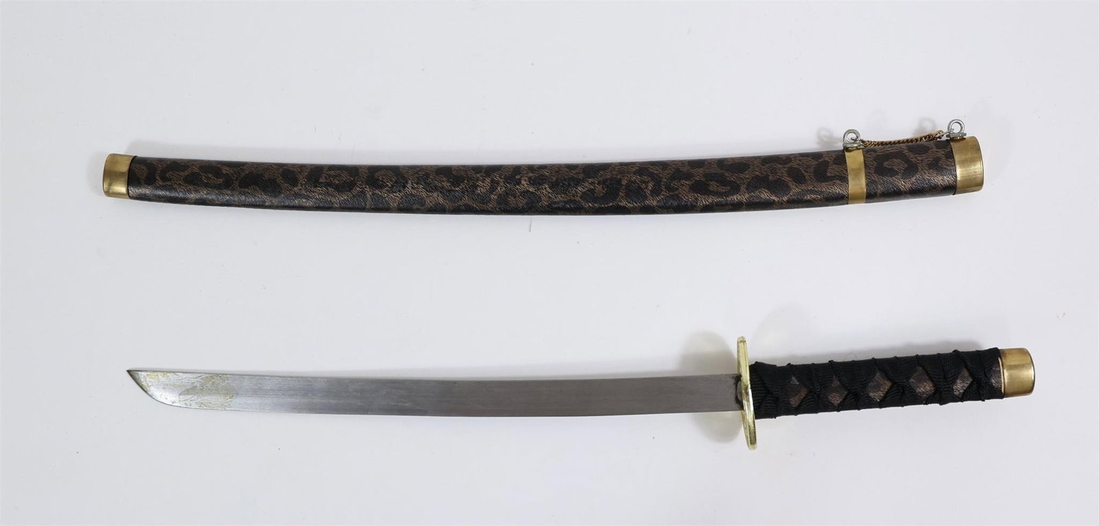 Decorative Japanese Samurai Katana: Decorative Japanese Samurai KatanaThe item in the image is a decorative Japanese Samurai sword, specifically a katana, featuring a distinctive patterned scabbard (saya) and a gold-colored guard