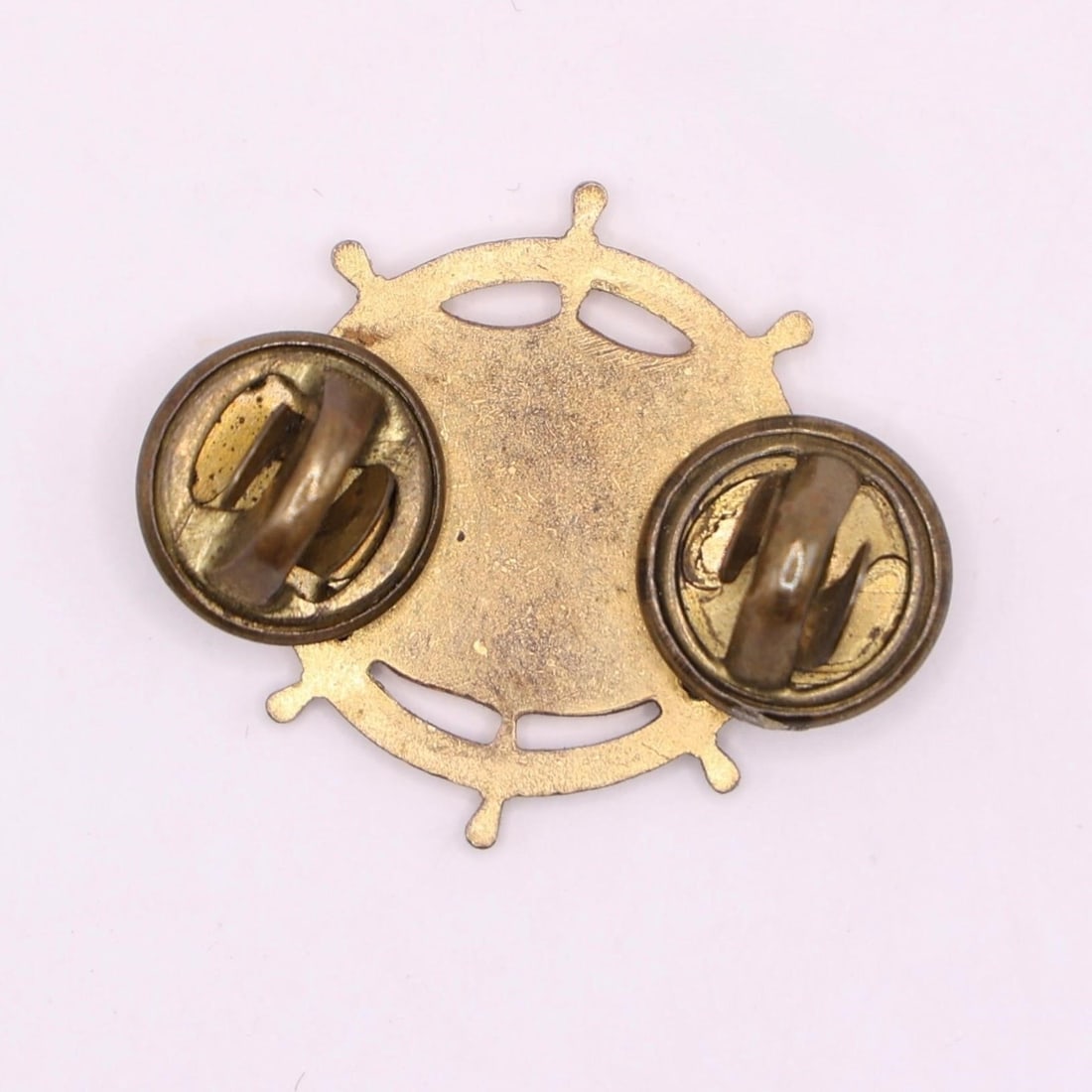 WWII US Army Transportation Corps Insignia Pin: This is a U.S. Army Transportation Corps officer's branch insignia pin, often considered a collectible item. The insignia features a ship's steering wheel, a shield, and a winged car wheel on a rail.