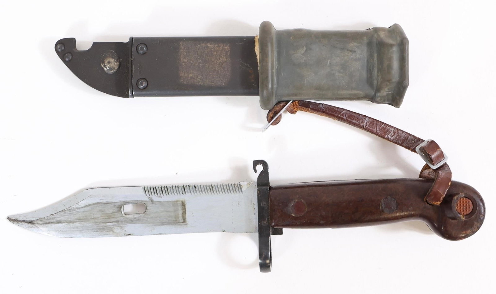 Russian Military Bayonet w/ Scabbard: Russian military bayonet featuring a fullered blade with sawback spine, steel guard with muzzle ring, and brown composite grip with rivets. Marked "BK 2531" on guard. Includes metal scabbard with rubb