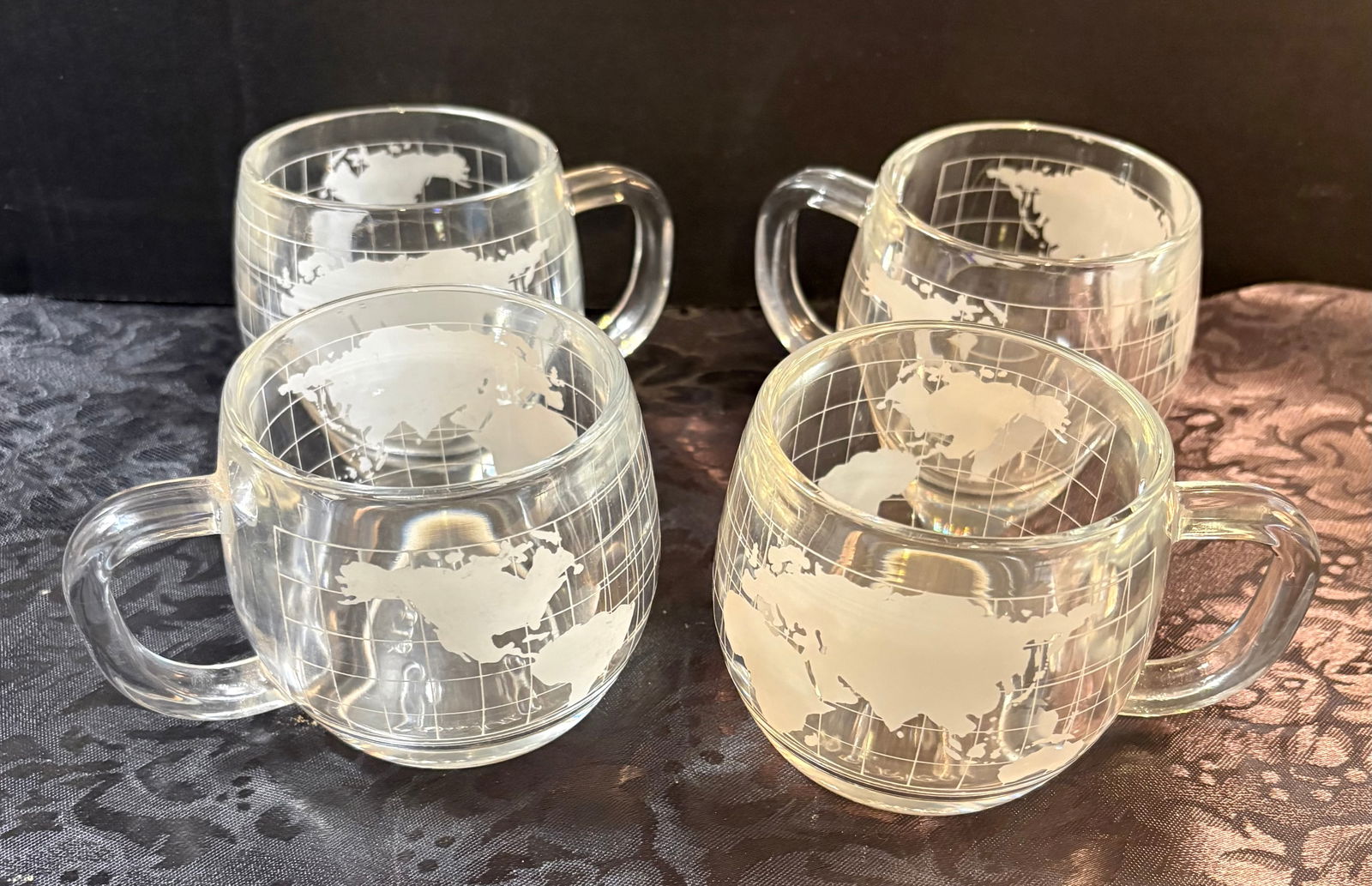 Vintage (1970s) Nestle Nescafe Etched Clear Glass Coffee Mugs x4: This lot features a set of 4, vintage 1970s Nestle Nescafe etched clear glass coffee mugs that feature a world globe map design. These mugs were part of a promotional campaign by Nestle. They are now