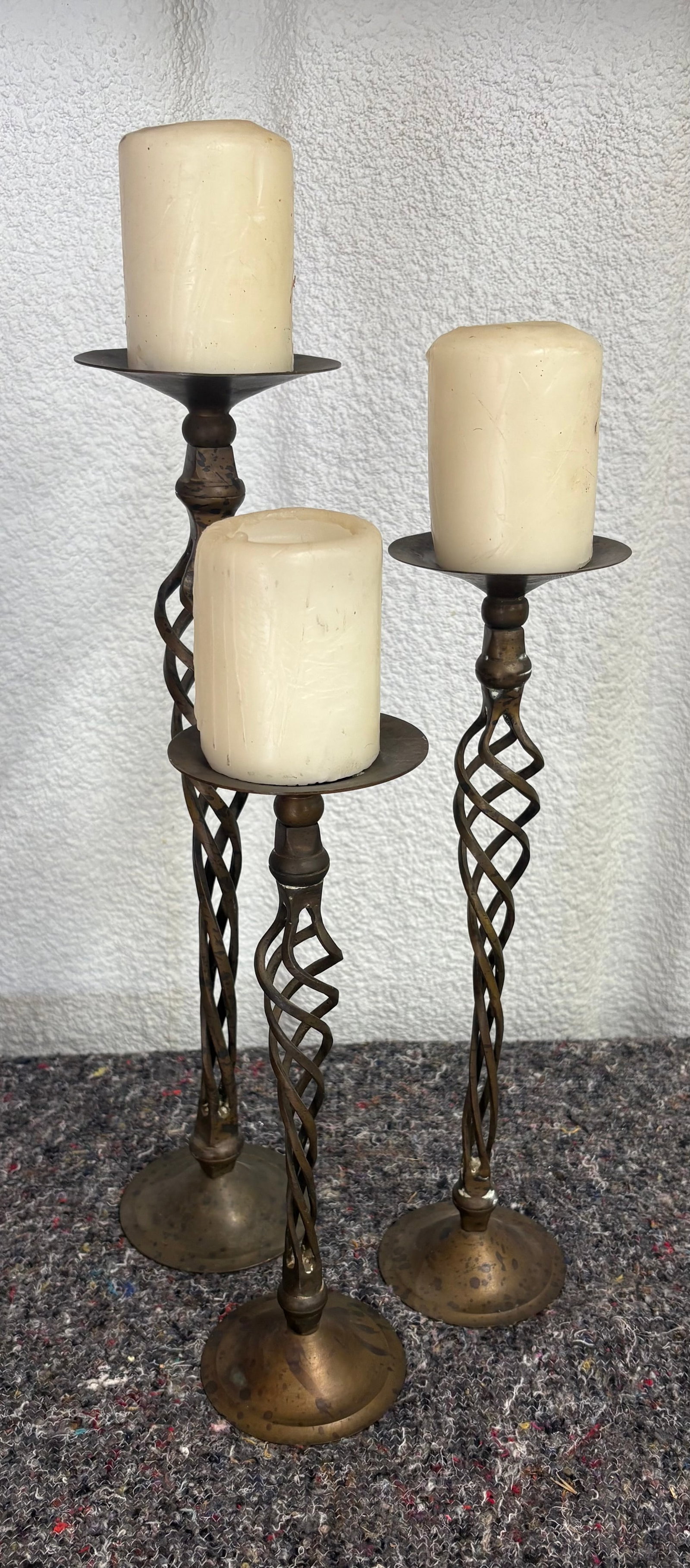 Vintage Trio of Brass Pillar Candle Holders w/Distinctive "Barley Twist" Stems: Vintage brass pillar candle holders w/distinctive "barley twist" stem. The stems use a decorative spiral or open cage-like twist. They measure (approximately) the following in height: 18 1/2", 15 1/2"
