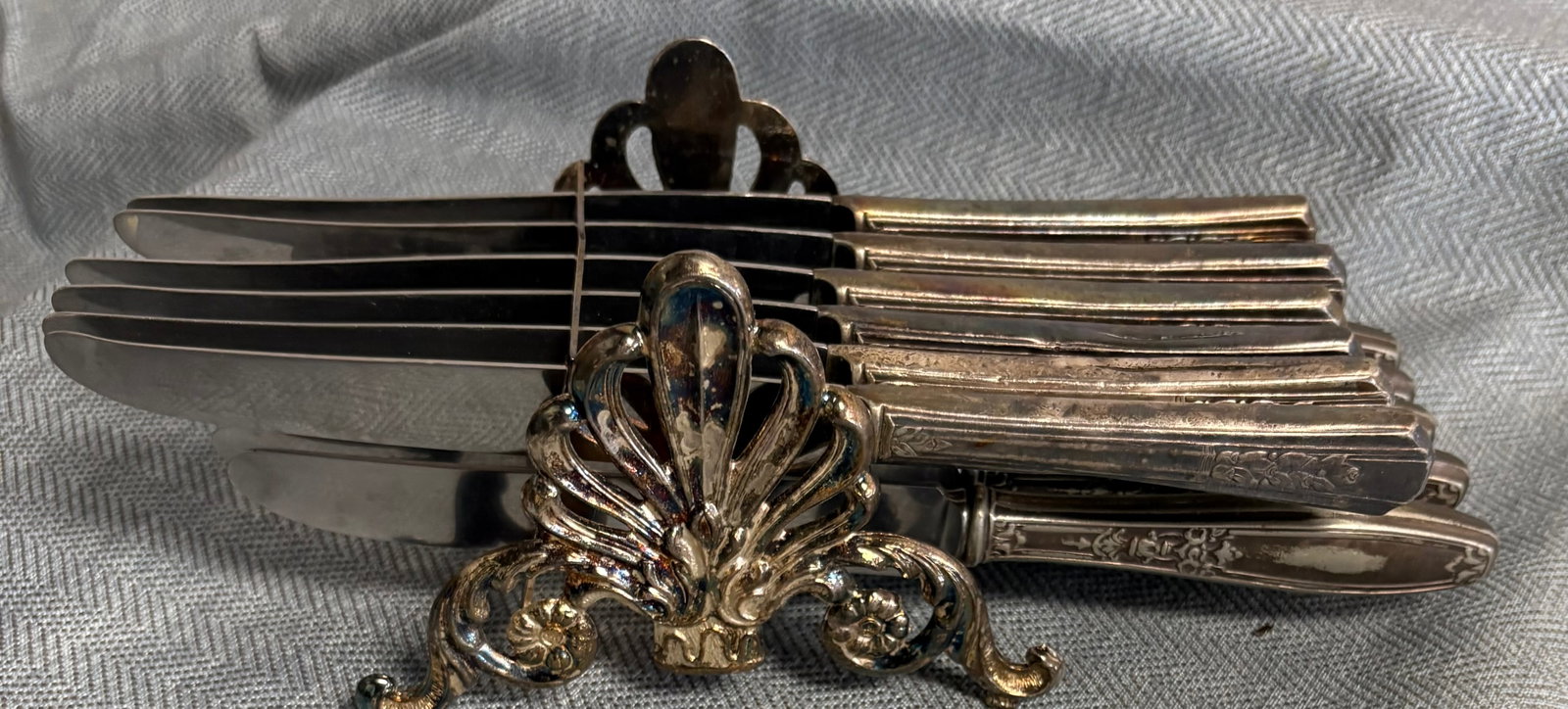 Vintage (MCM) Silver-Plated Knife Rest/Caddy + 11 Silver-Plated Knives: Vintage silver-plated buffet knife rest (knife caddy) designed to hold knives in an organized & decorative manner. It features an ornate, symmetrical shell-like design often referred to as an Agapanth