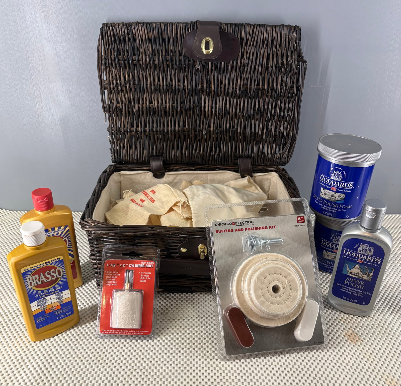 Silver & Brass Shine, Polishers, & Protective Pouches Collection: This lot features a collection of Silver and Brass shine, medium sized jewelry/silver pouches, and a suitcase-style wicker basket with a leather handle and a brass latch. Not all shine pieces are full