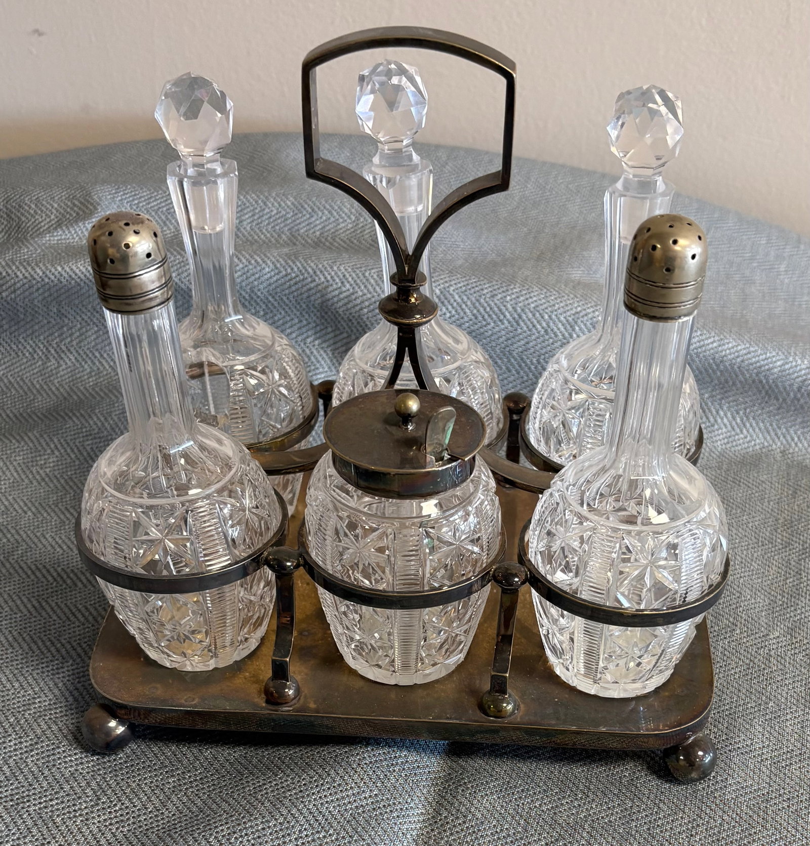 Antique (l1800s/e1900s) Victorian Silver-Plated Cruet Set: Antique Victorian silver-plated cruet set, a popular dining accessory from the late 19th century used to hold various condiments. It consists of a decorative silver-plated caddy or stand with a centra