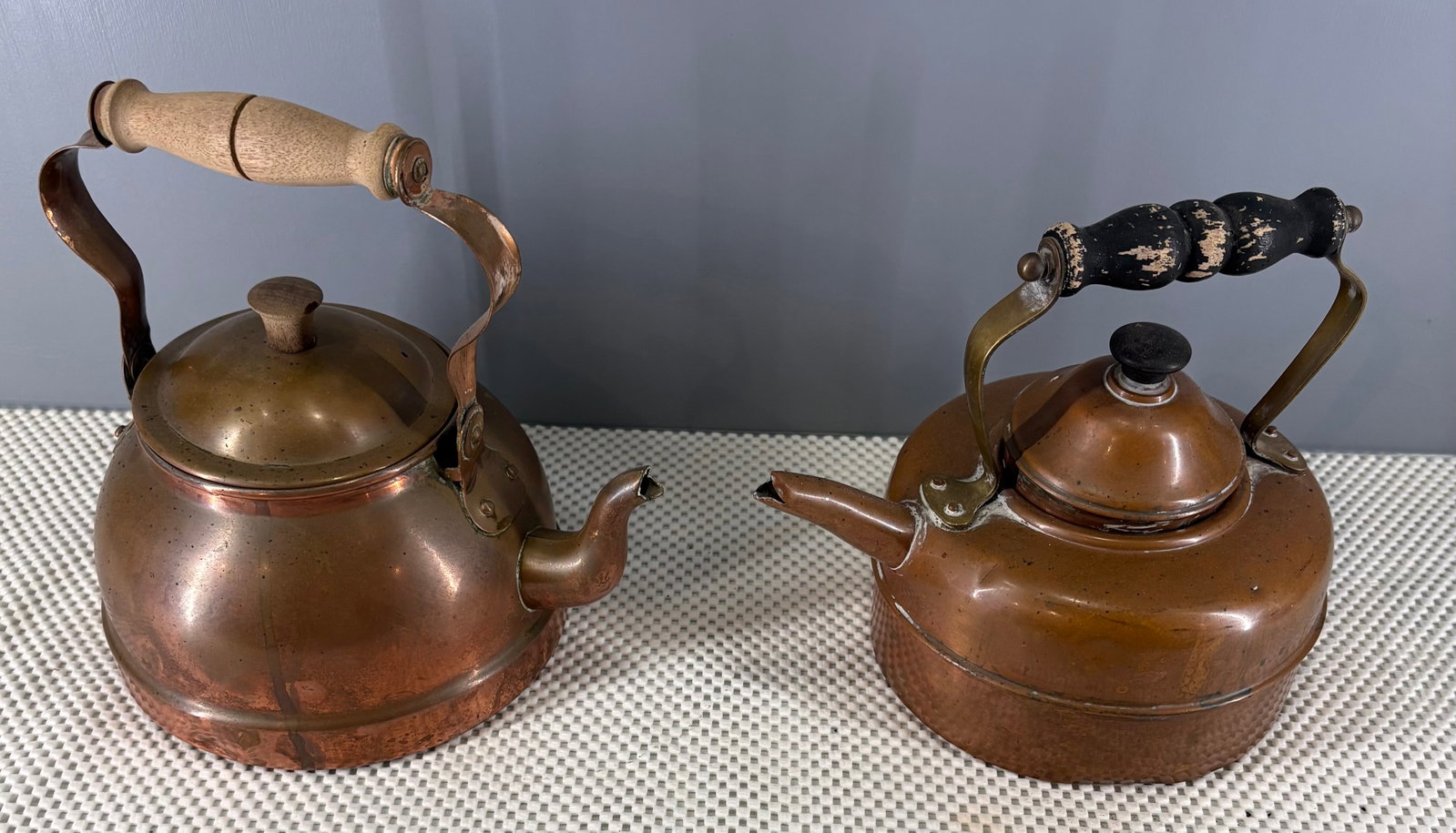 Antique British & Portugal Copper Kettles w/Removable Lids: Two Antique copper kettles with wood handles, likely dating to the late 19th century to early 20th century. One kettle is Made in England, hallmarked at the bottom while the other is made in Portugal,