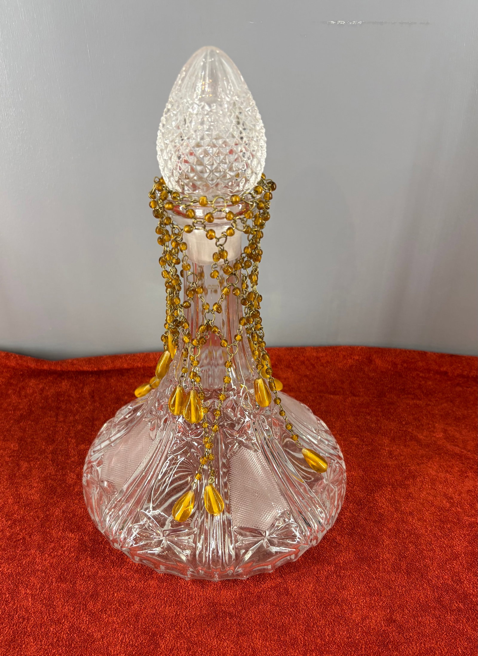 Vintage Wexford Clear-Cut Glass Decanter - Anchor Hocking: Vintage Anchor Hocking Wexford clear cut glass decanter adorned with a decorative amber beaded drape. It features the classic Wexford pattern from Anchor Hocking, which is easily recognizable by its d