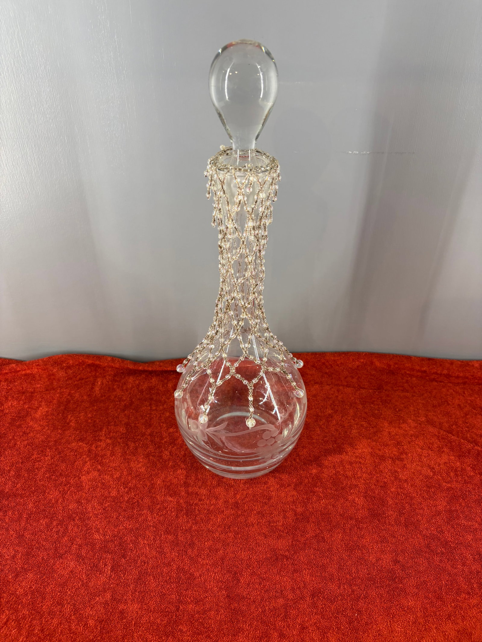 Vintage Etched Glass Bulbous Base Decanter w/Beaded net Overlay: Vintage etched glass decanter featuring a removable decorative seed bead net overlay and a solid glass tear-drop stopper. It features a classic bulbous teardrop base and a long, slender neck with deli