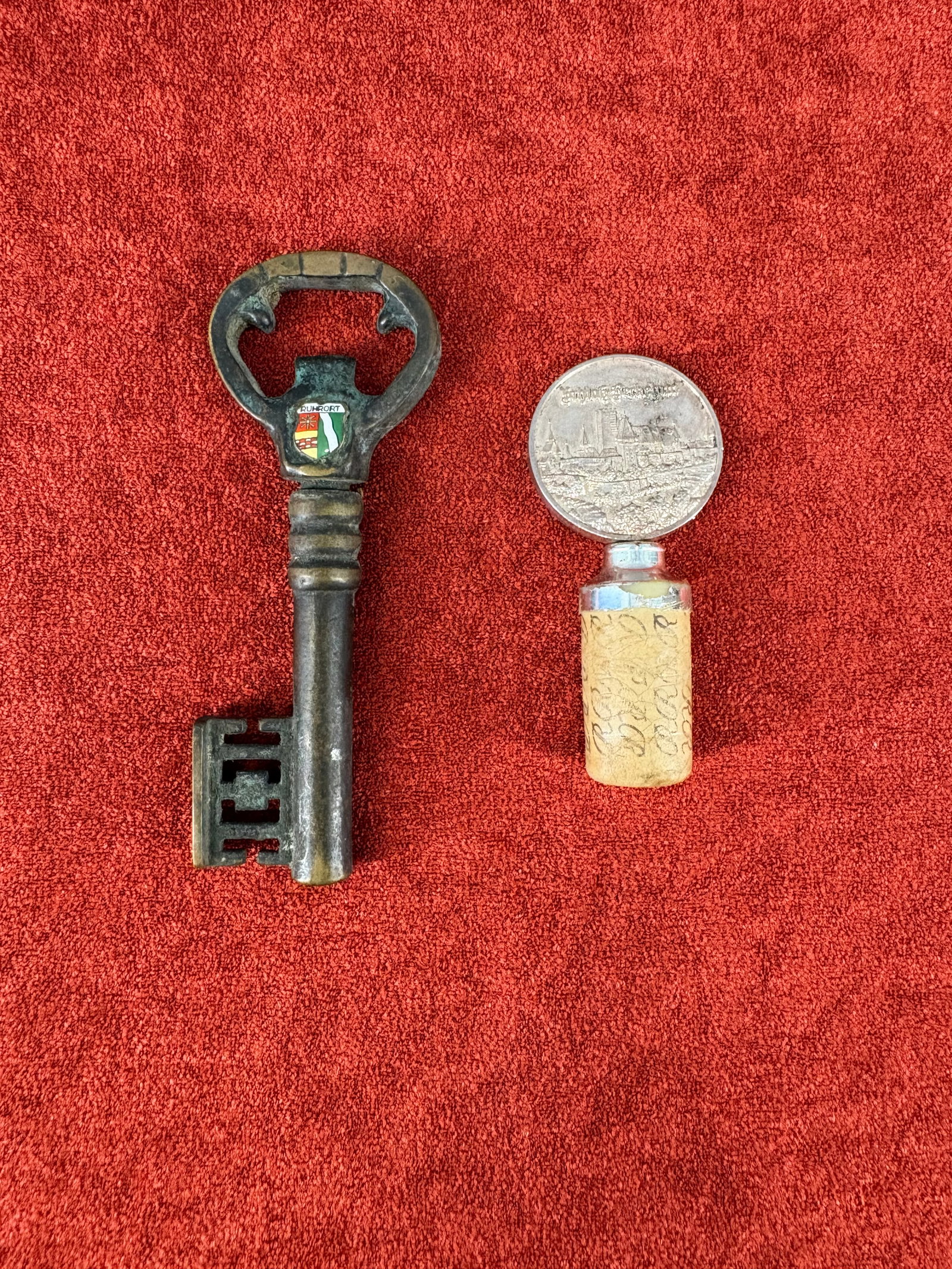 Vintage (1950s/60s) German Bar Accessories Commemorative Collection: A collection of vintage, commemorative German bar accessories, including a multifunctional skeleton-key bottle opener and a relief-medallion wine bottle stopper. Specifics include...1). Key Bottle Ope