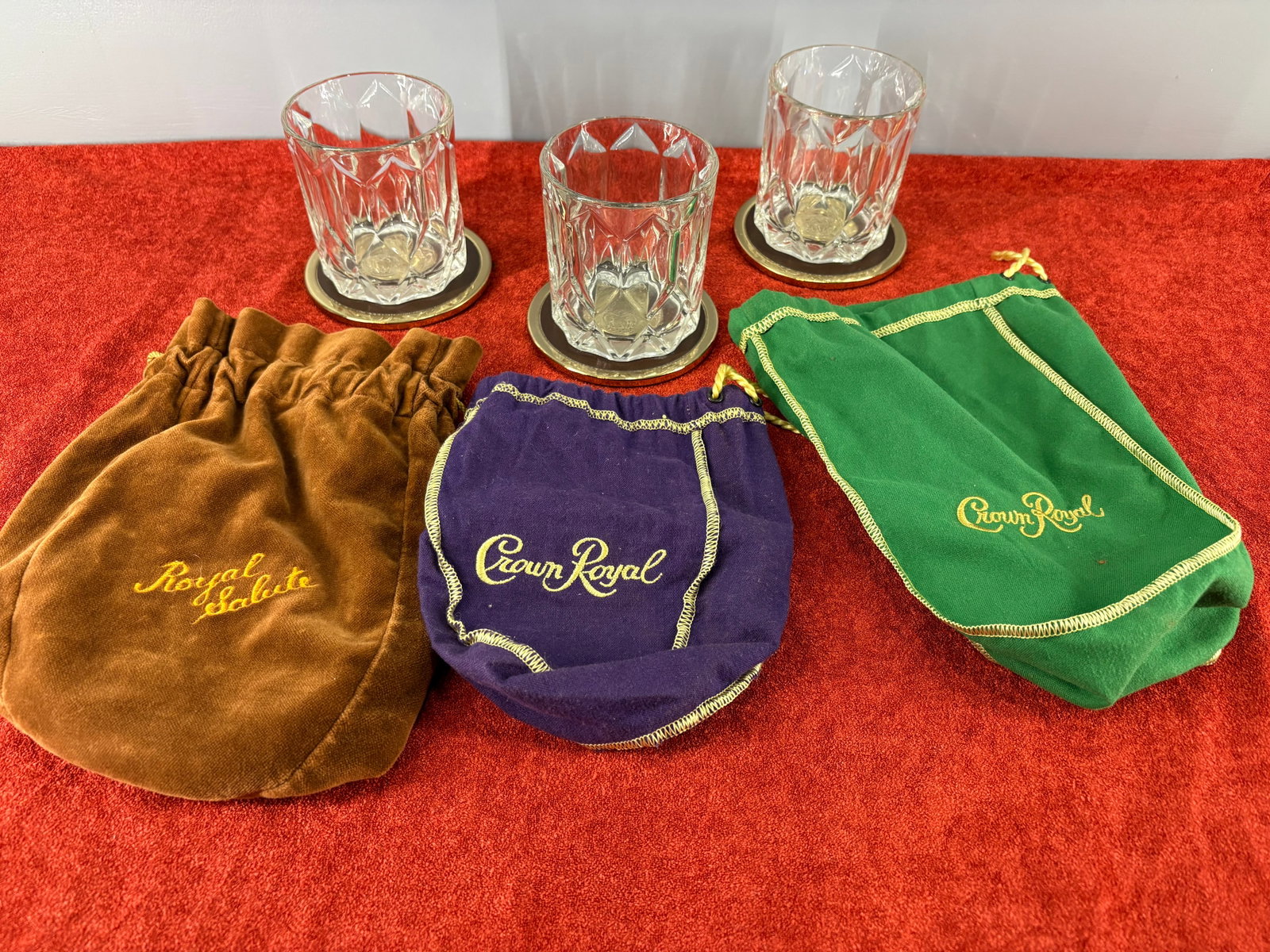 Vtg 9-Piece Crown Royal Whiskey Collector's Lot: A collector's lot of collectible Crown Royal whiskey bags and crystal lowball glasses. This lot includes...1). Brown Velvet Bag - A plush velvet pouch stitched with gold embroidery for Chivas Brothers