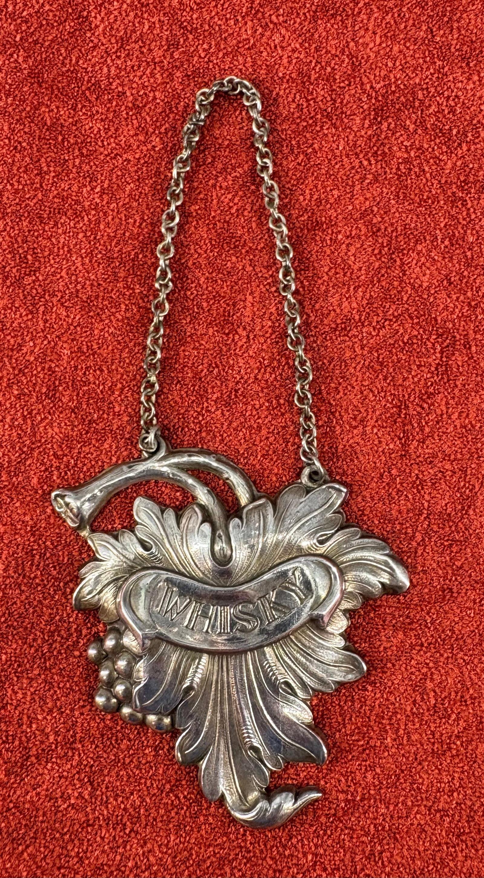 Antique (ca 1920s) Silver-Plated (Portuguese) Decanter Label - Whisky: Vintage, possibly antique (ca. 1920s?) silver-plated grape leaf decanter label. It is cleanly embossed or engraved with the word "WHISKY" across a central banner ribbon. Highly detailed repoussé and 