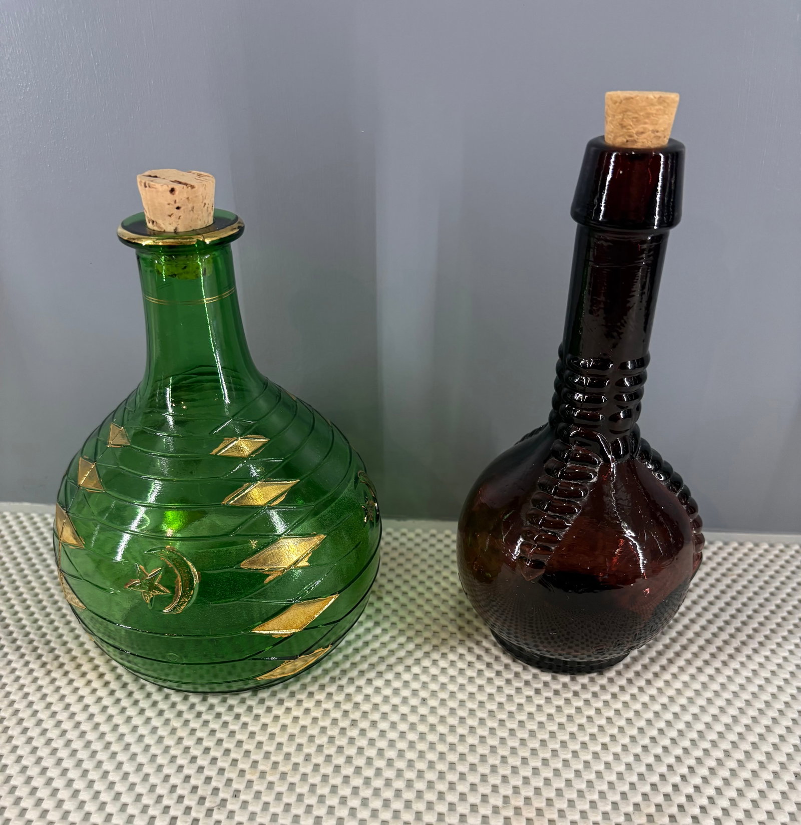 Vintage (1930s-50s) Collectible Mastercraft & Amethyst Glass Bottles: Two distinct collectible vintage glass bottles, both fitted with cork stoppers. They include...1). Mastercraft Pipes Hookah Bottle - Manufactured in Italy, vintage 1930s - 1950s. Crafted from emerald 