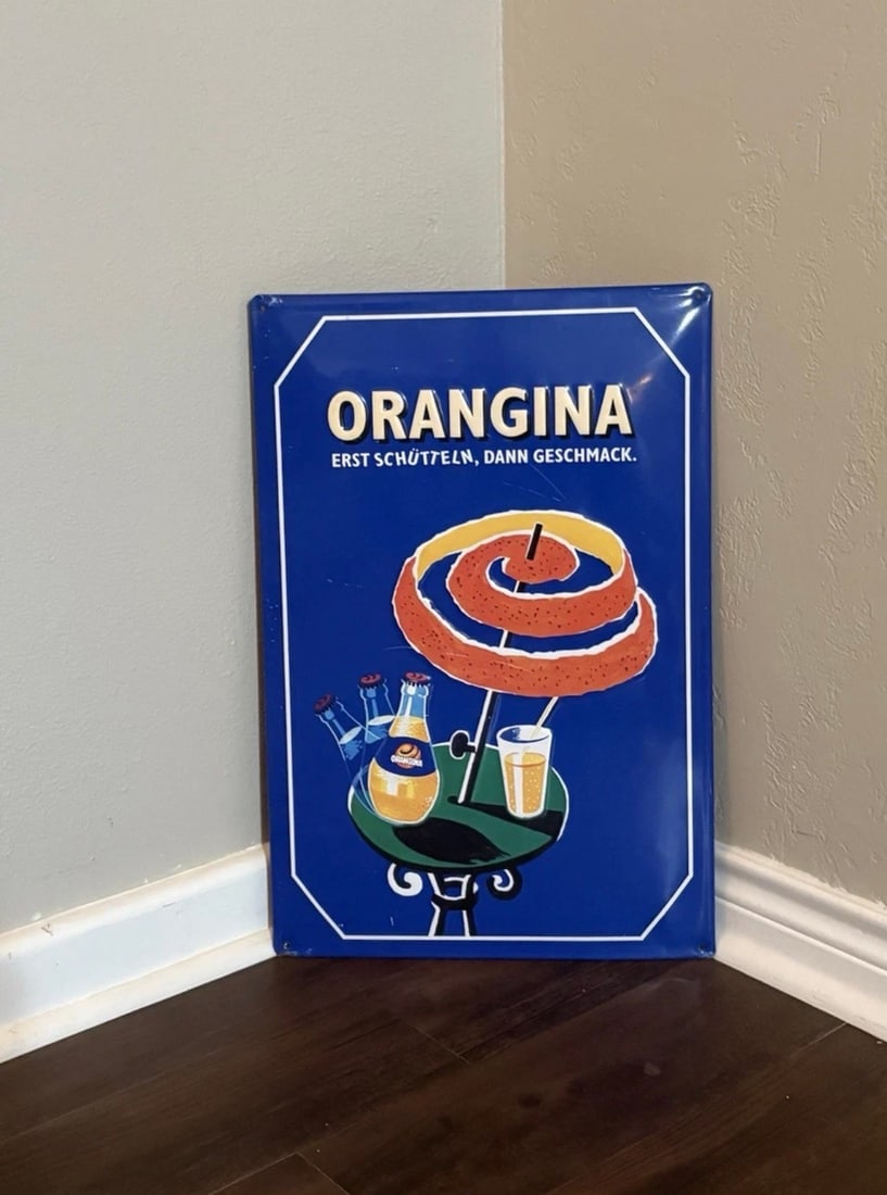 Vintage (ca. 1990s) German (Tin) Orangina Embossed Advertising Sign: This is an authentic German Orangina advertising sign. It's a modern tin reproduction of the original advertising poster designed by the French graphic artist Bernard Villemot (1911-1989). The signs d
