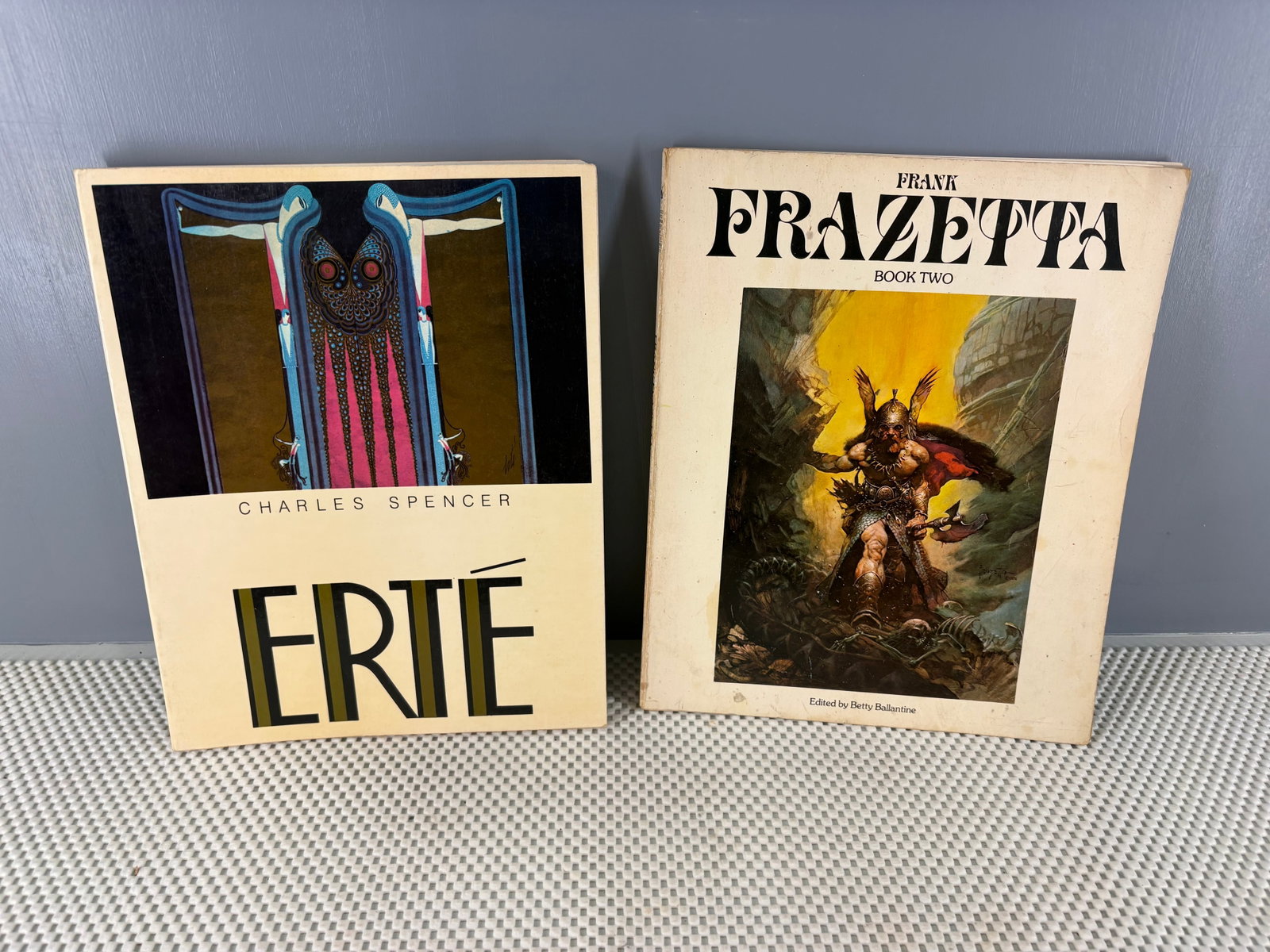 2x Vintage Art Books - Erté & Frazetta: Two classic art monograph softcover/hardcover books. They include...1). Erté by Charles Spencer - an extensive look at the iconic Art Deco illustrations, fashion, and theater designs of the artist Er