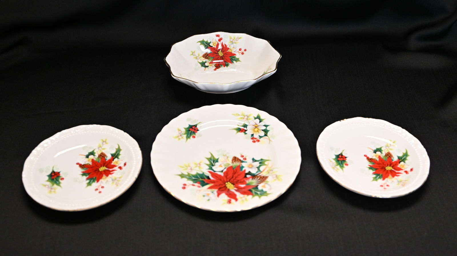 Royal Albert Poinsettia Bone China Dessert Set, 4 Pcs, England: An elegant four-piece dessert or accent set in the festive "Poinsettia" pattern by the renowned maker Royal Albert. Made in England from fine bone china, this set is distingui