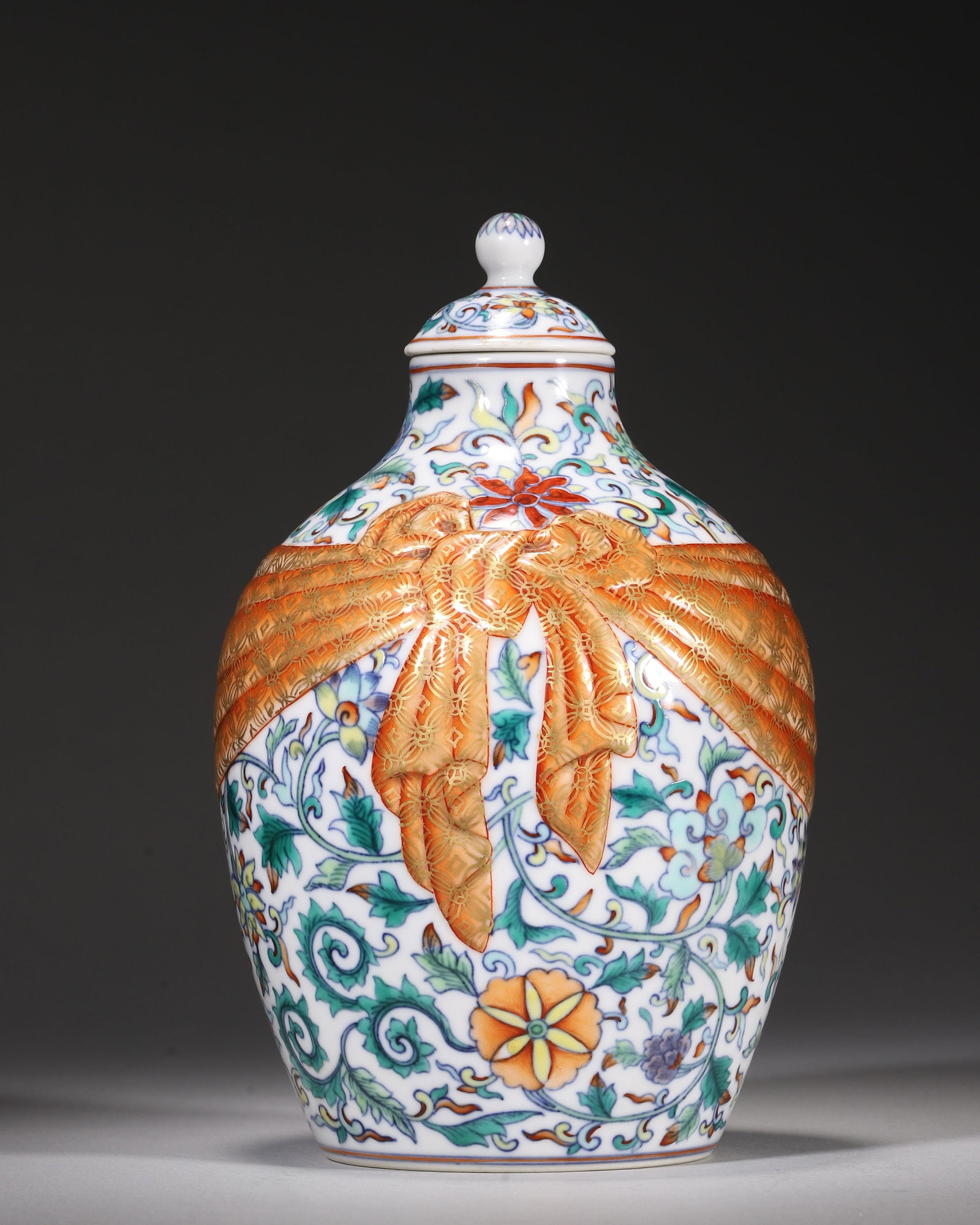 A DOUCAI LIDDED JAR WITH FLORAL SCROLLS AND GILT CORAL RED RIBBON SASH, QIANLONG PERIOD, QING (1 of 7)