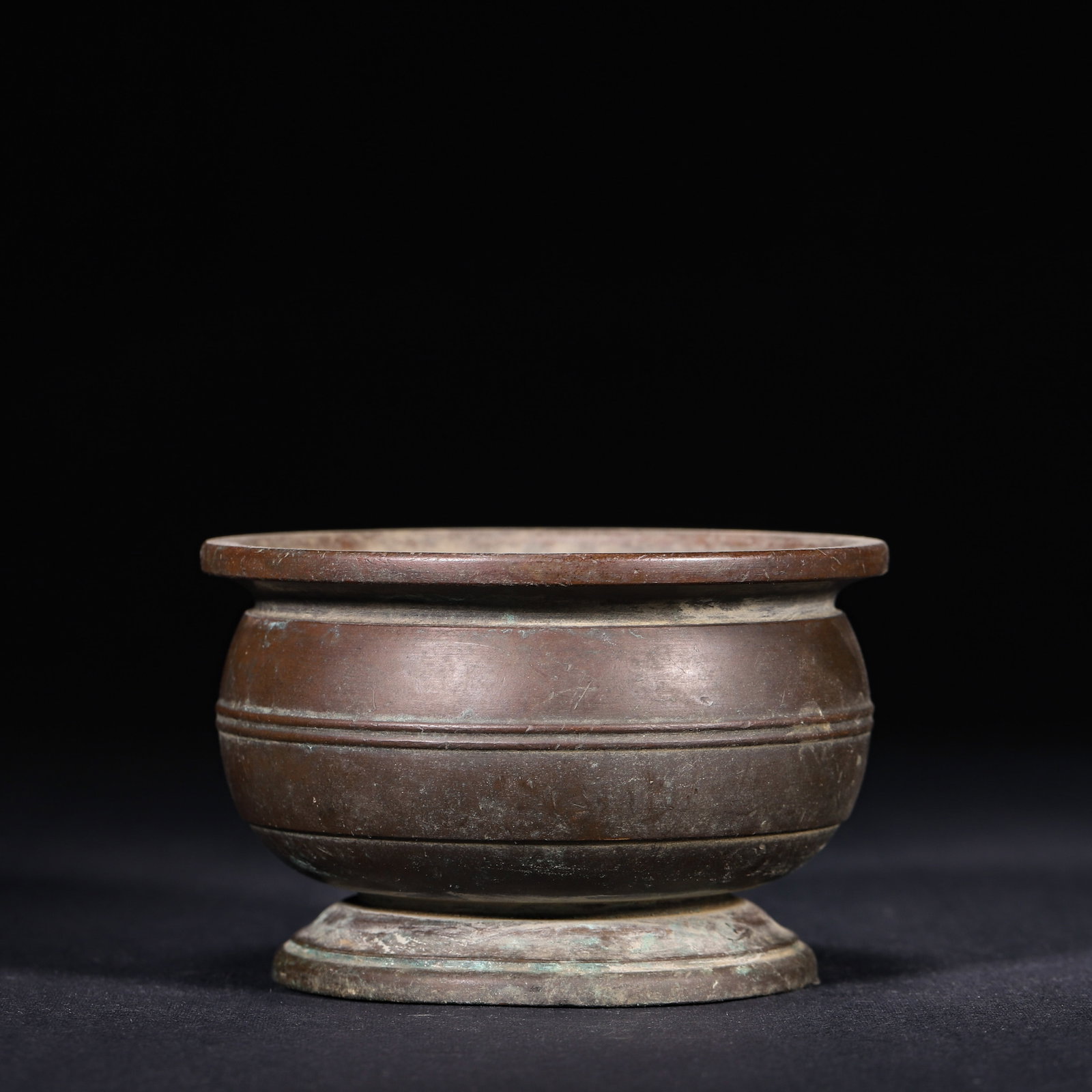 Bronze Censer with String Patterns, Xuande Period, Ming Dynasty: Wt 595g (1.31 lb); D 9.5cm (3.74 in); H 6cm (2.36 in)Finely cast bronze censer of Xuande period. Flared rim, compressed bulbous body supported by circular foot. Decorated with simple raised string mou