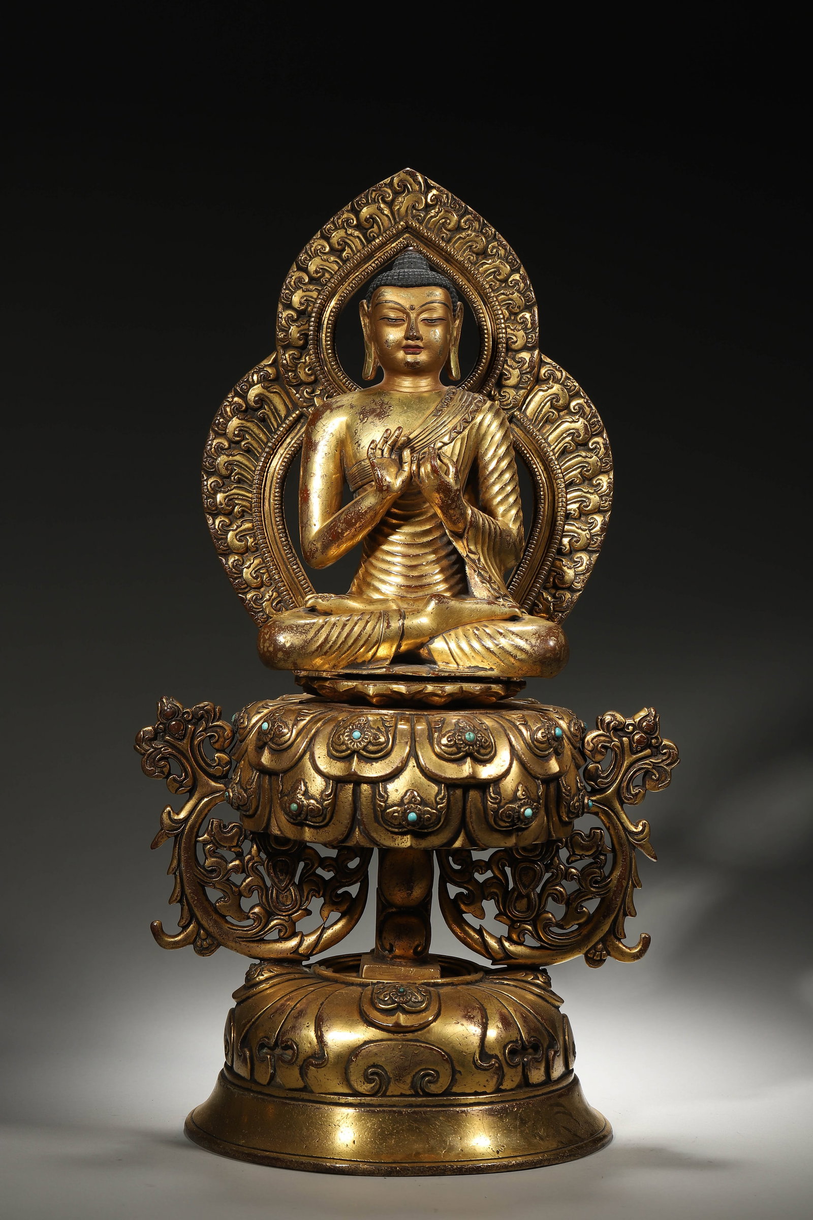 A Gilt Bronze Statue of Dipankara Buddha with Turquoise Inlays, Qing Dynasty: L 23cm (9.06 in); W 20cm (7.87 in); H 46cm (18.11 in); Wt 8.09kg (17.84 lb)This gilt bronze statue depicts Dipankara Buddha, an important Buddha in Tibetan Buddhism, inlaid with turquoise. With elegan