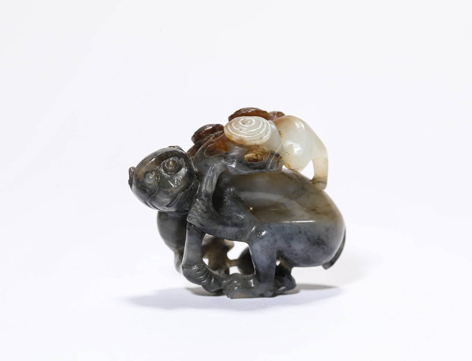 A Blue and White Jade 'Monkey on a Horse': A Blue and White Jade 'Monkey on a Horse' Dimensions: Length: 3.7 cm (1.46 in) x Width: 2.0 cm (0.79 in) x Height: 4.4 cm (1.73 in). All measurements are approximate.