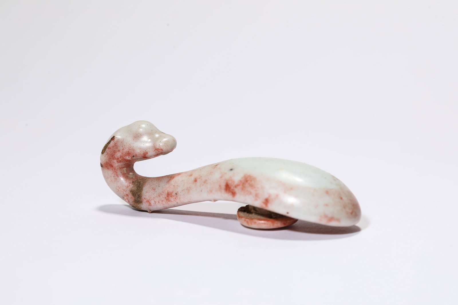 A Porcelain Belt Hook: A Porcelain Belt Hook Dimensions: Length: 7.2 cm (2.83 in). All measurements are approximate.