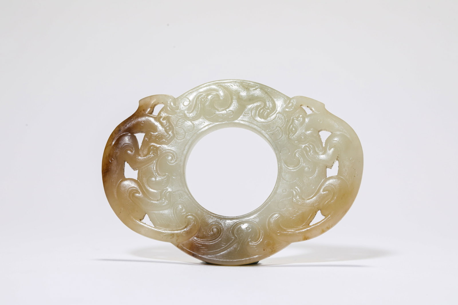A Jade 'Double Dragon' Bi Disc: A Jade 'Double Dragon' Bi Disc Dimensions: Width: 7.6 cm (2.99 in) x Height: 5.5 cm (2.17 in). All measurements are approximate.
