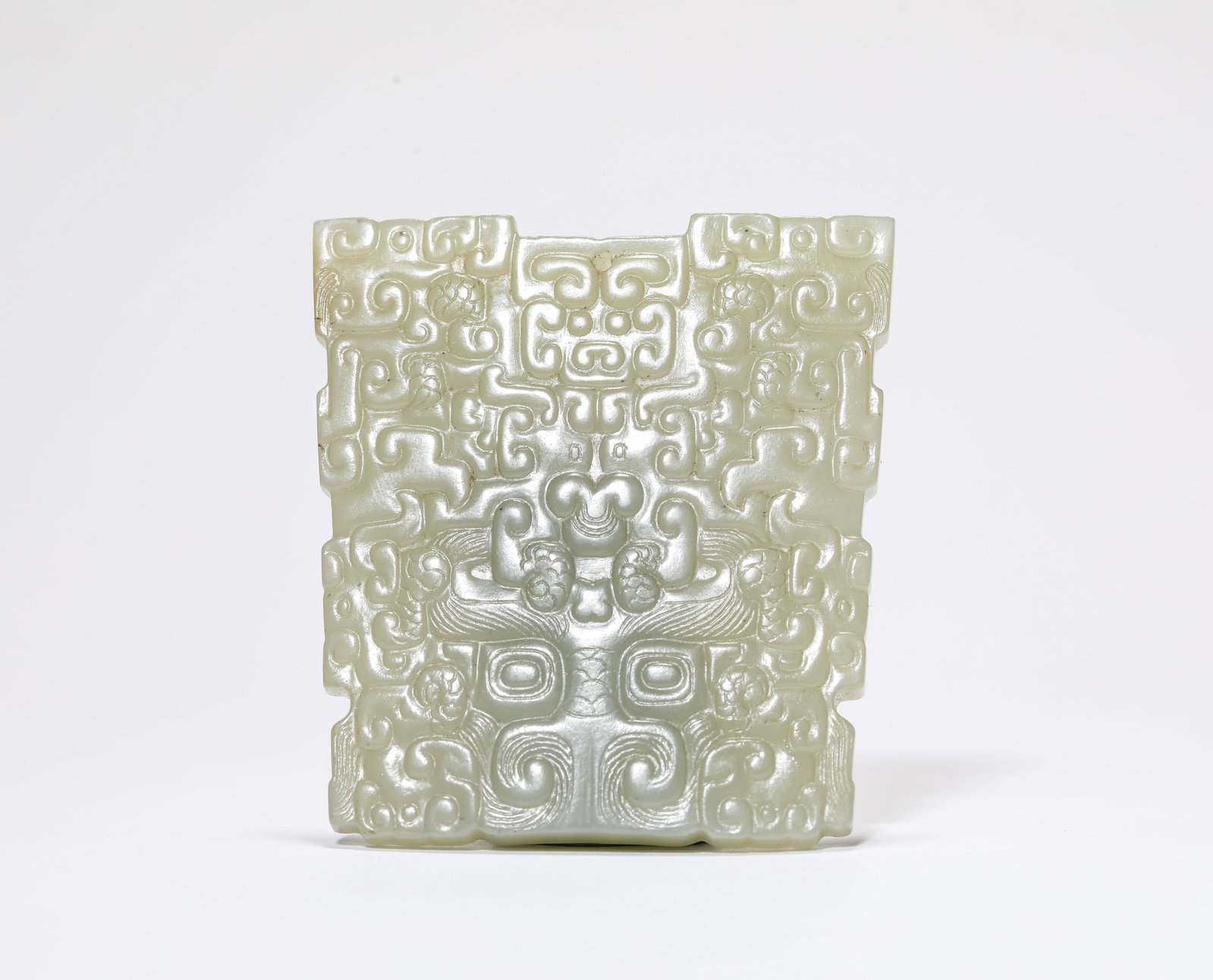 A Jade 'Carved Animal Mask' Pendant: A Jade 'Carved Animal Mask' Pendant Dimensions: Width: 5.5 cm (2.17 in) x Height: 6.0 cm (2.36 in). All measurements are approximate.