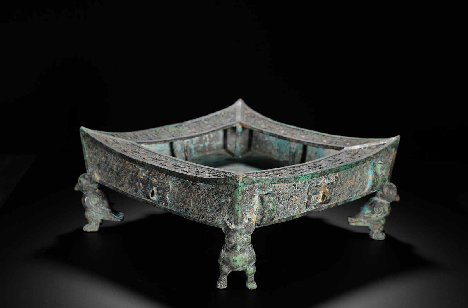 A Shang Dynasty Bronze 'Bird-Leg' Square Dish: A Shang Dynasty Bronze 'Bird-Leg' Square Dish H:13cm (5.12in) W:28cm (11.02in) Weight:6020g (13.27lb)This is a Shang Dynasty bronze food vessel. Square-shaped with bird legs and decorated with animal 